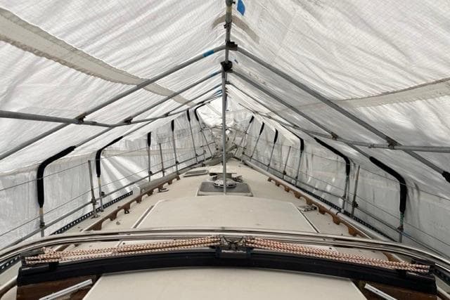 1982 Catalina 38 sailboat under protective cover, showcasing deck and rigging.