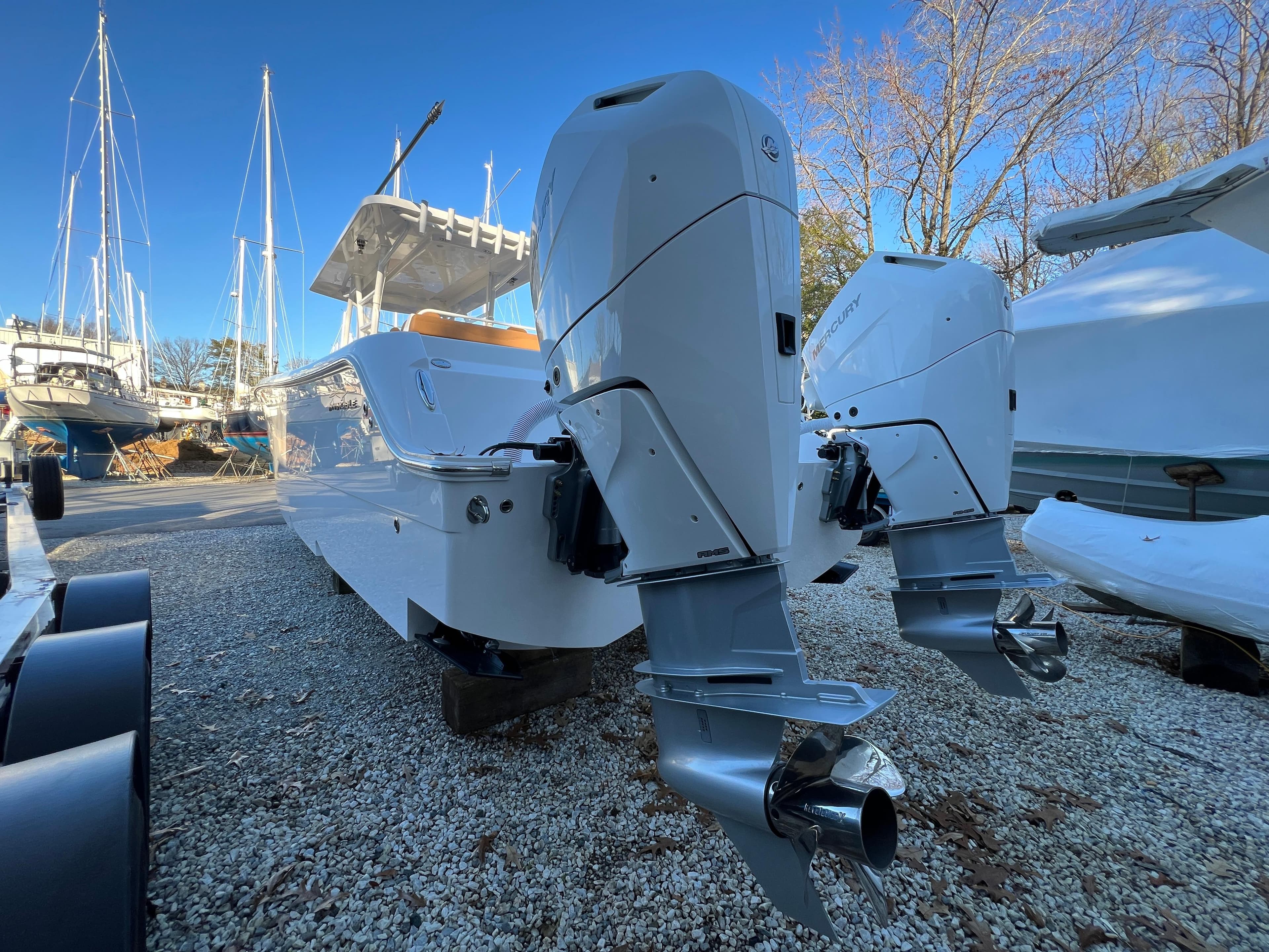 2025 Invincible 33 Catamaran with dual outboard engines in a boatyard.