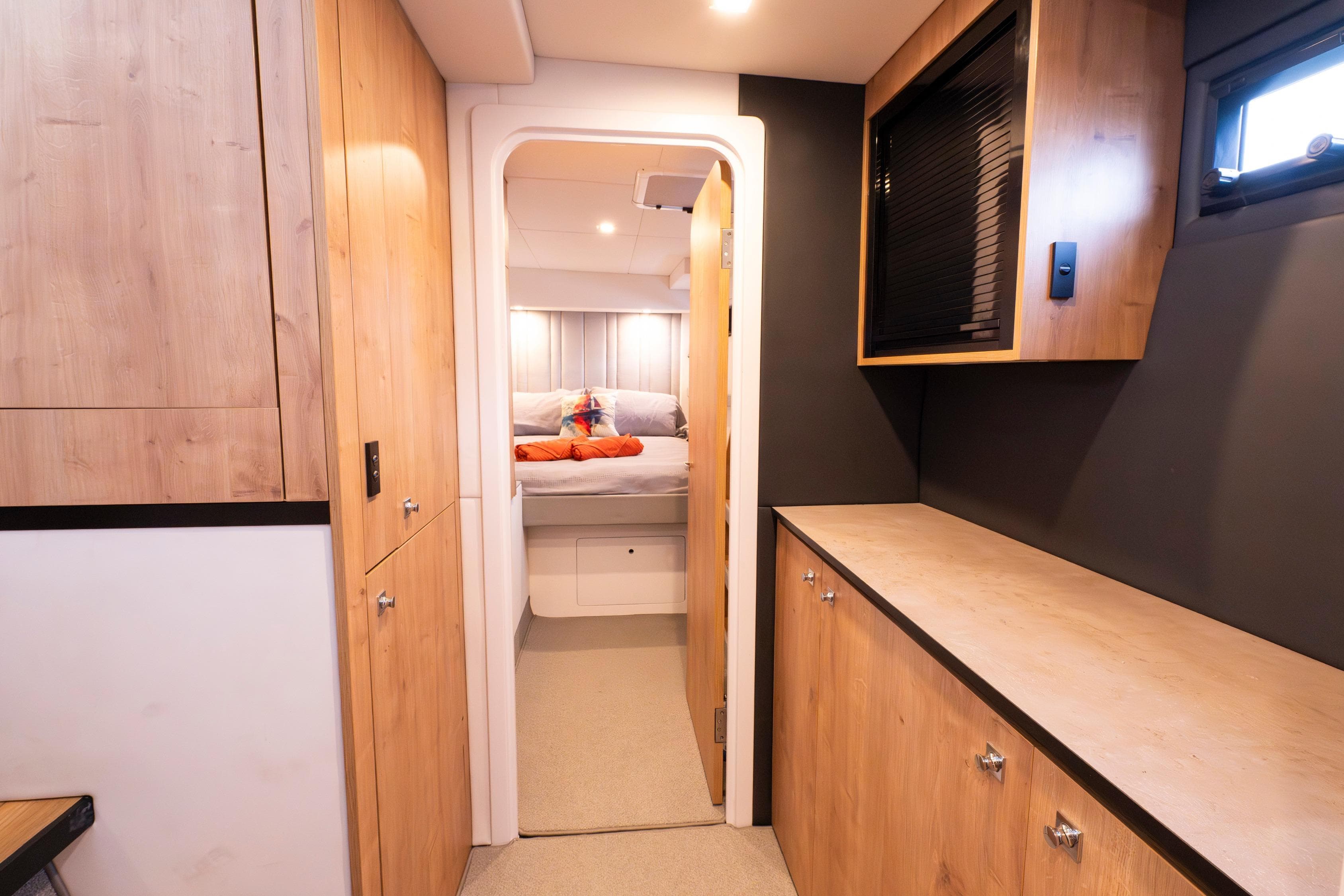 Modern interior of 2024 Bloomfield Custom 70 yacht with wood finishes and cozy bedroom.