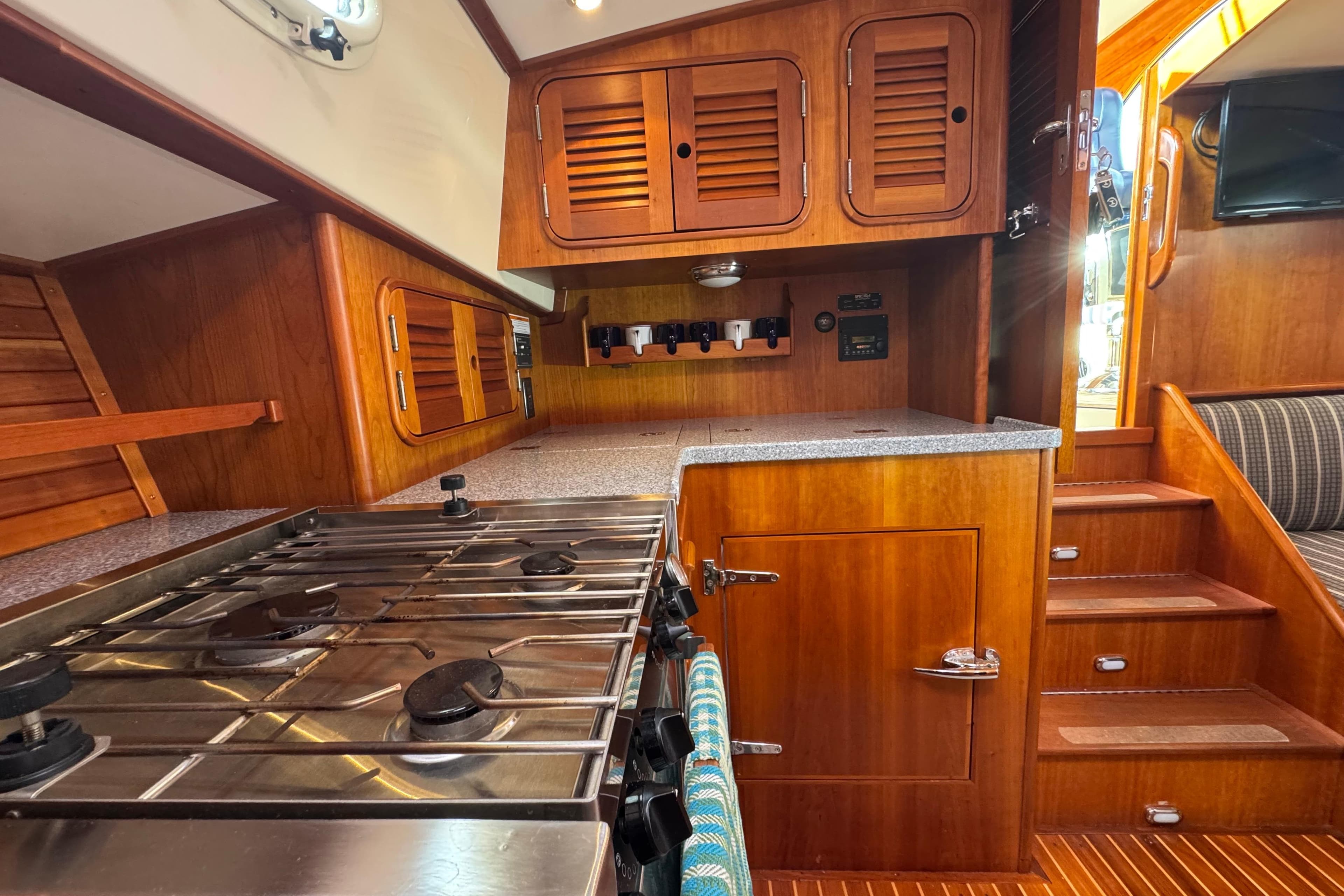 Hinckley Talaria 44 yacht interior kitchen with wooden cabinetry and stainless steel stove, 2001 model.