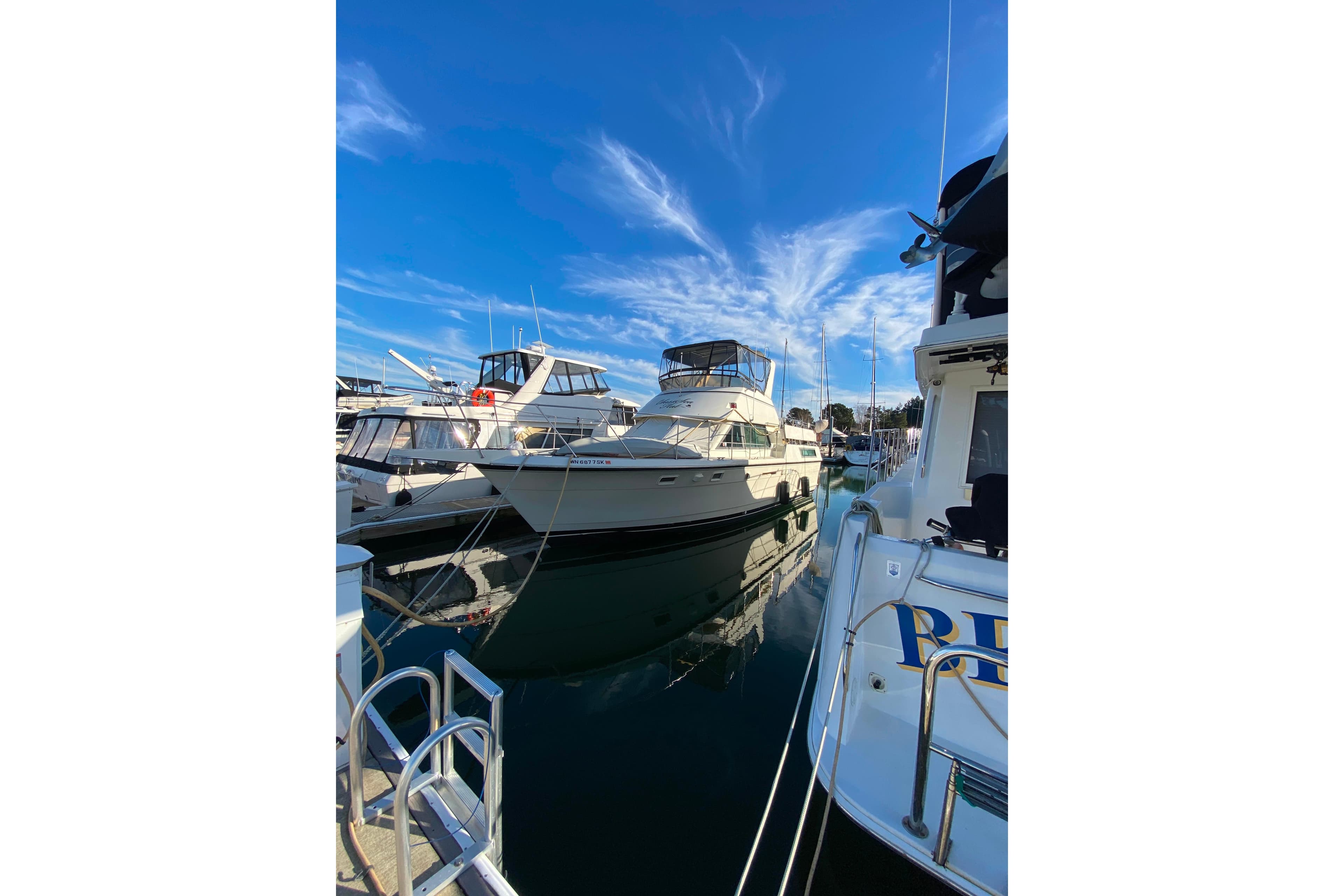 1988 Hatteras 40 Double Cabin yacht docked in a marina under a clear blue sky.