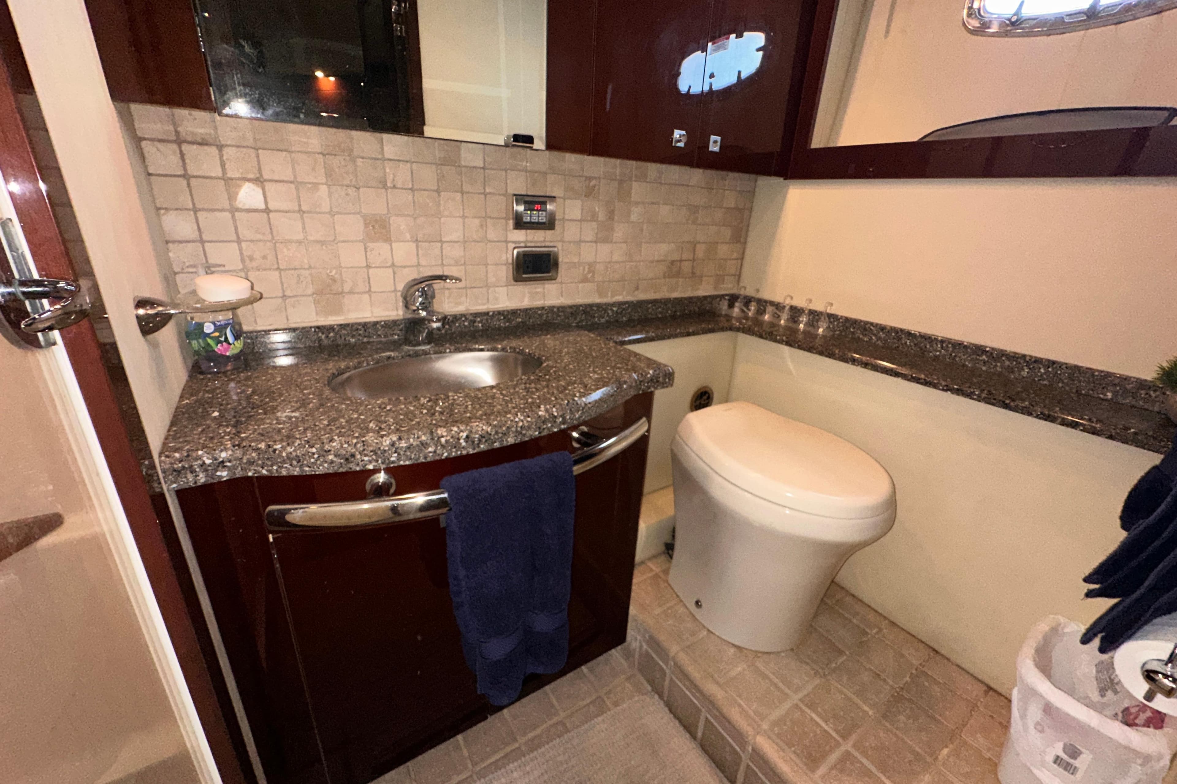 Luxurious bathroom in 2008 Sea Ray 55 Sundancer yacht with granite countertop and modern fixtures.
