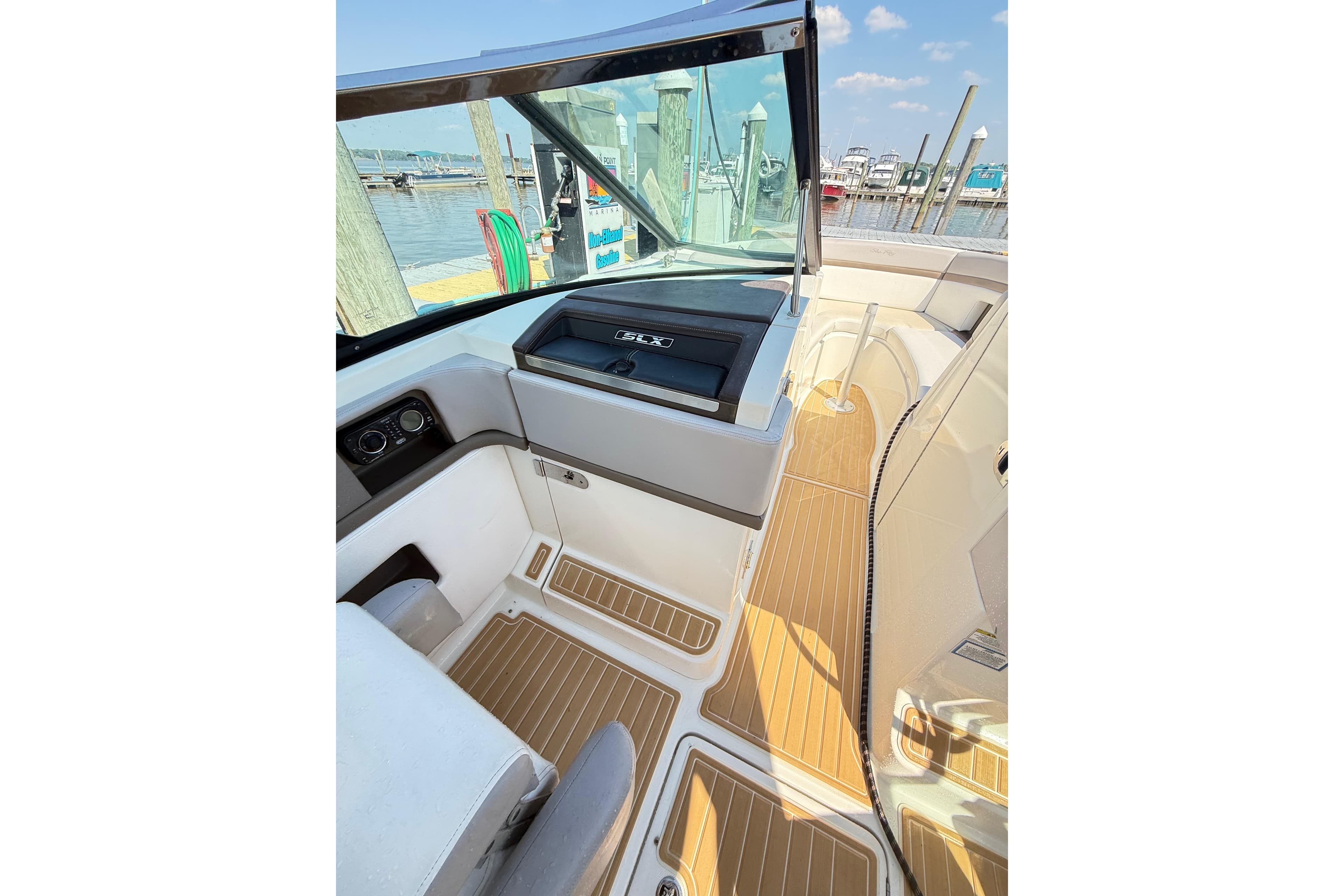Interior view of 2011 Sea Ray 270 SLX boat with wooden flooring at a marina.