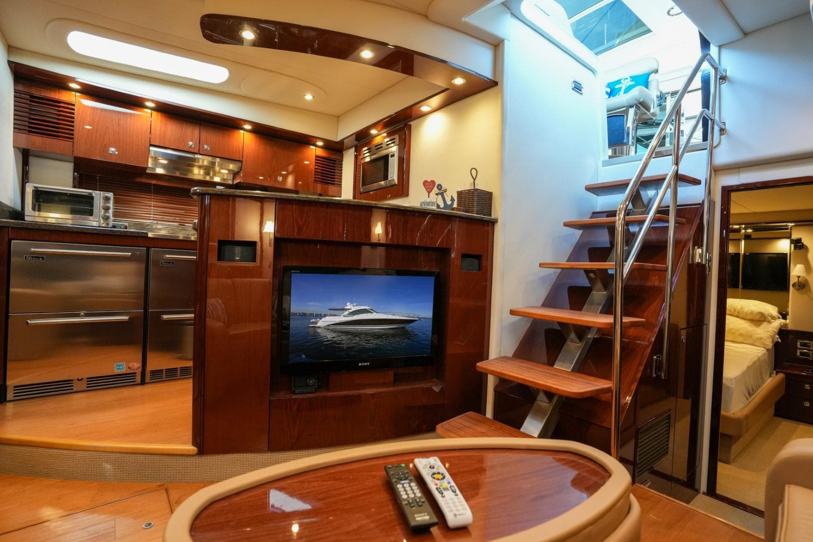 Luxurious interior of 2013 Sea Ray 610 Sundancer yacht with modern kitchen and entertainment area.