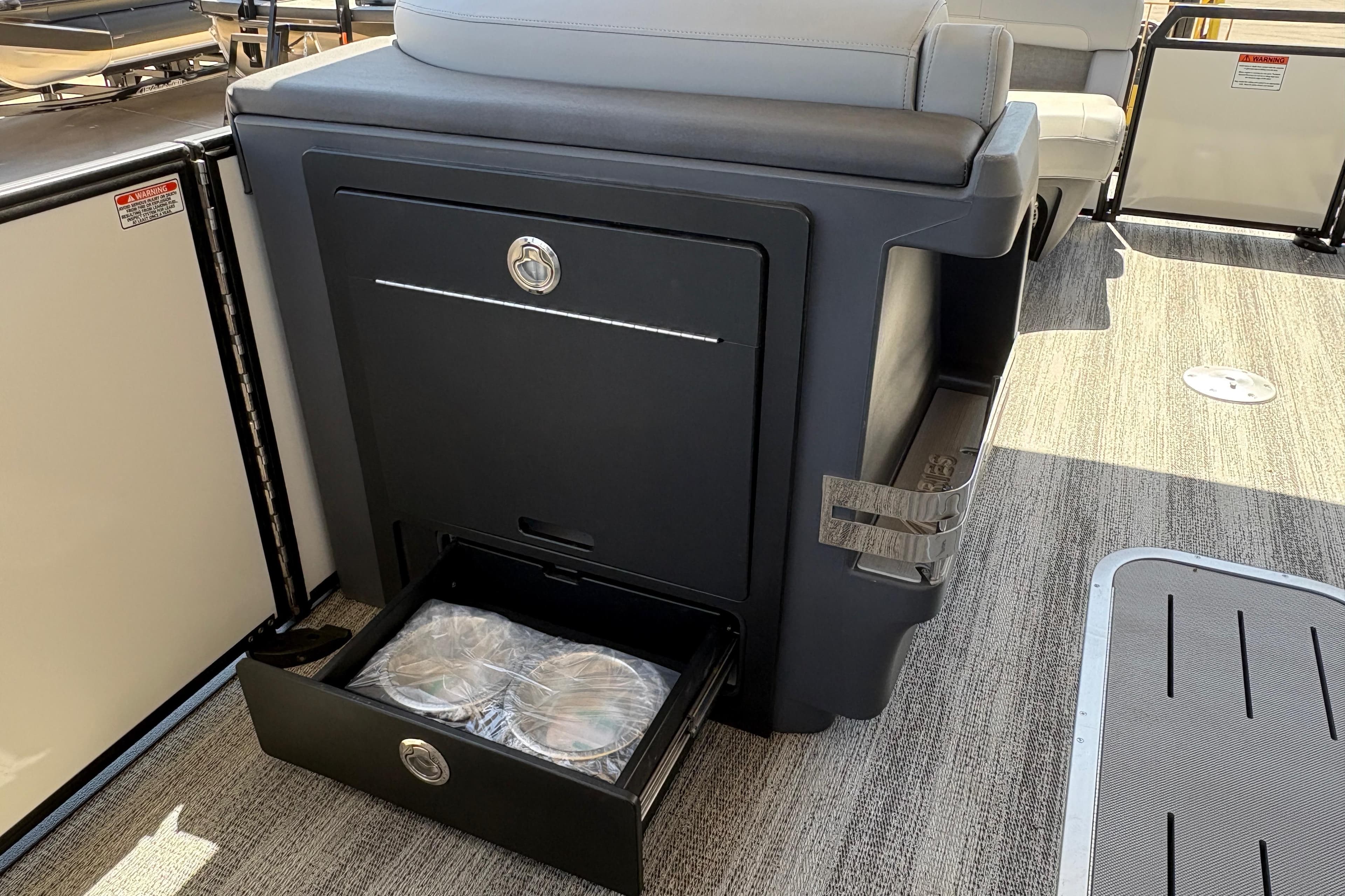 2026 Bennington 24 MSB boat interior with storage compartment and drawer open.