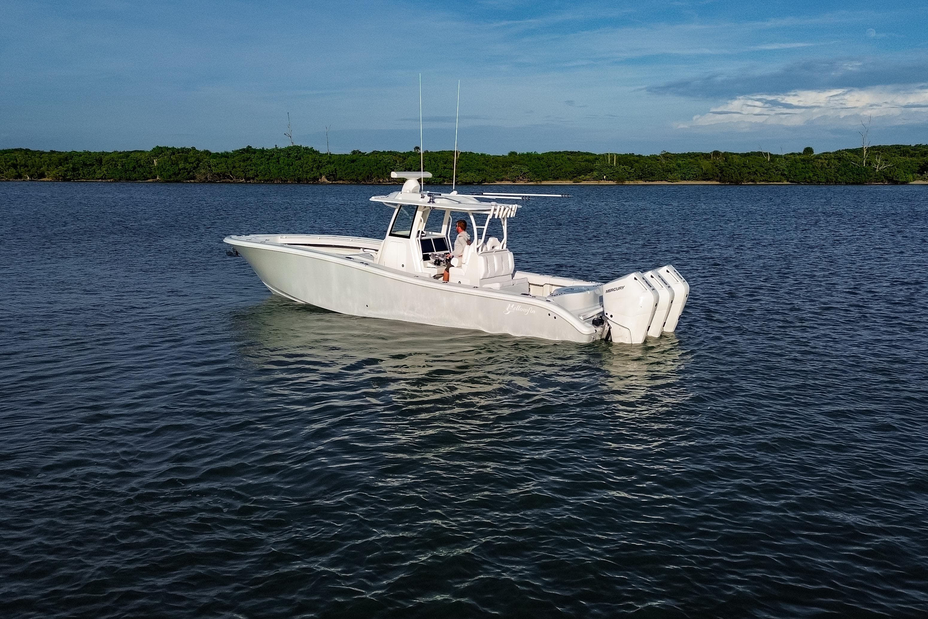 2026 Yellowfin 36 Offshore boat on calm water with triple outboard engines.