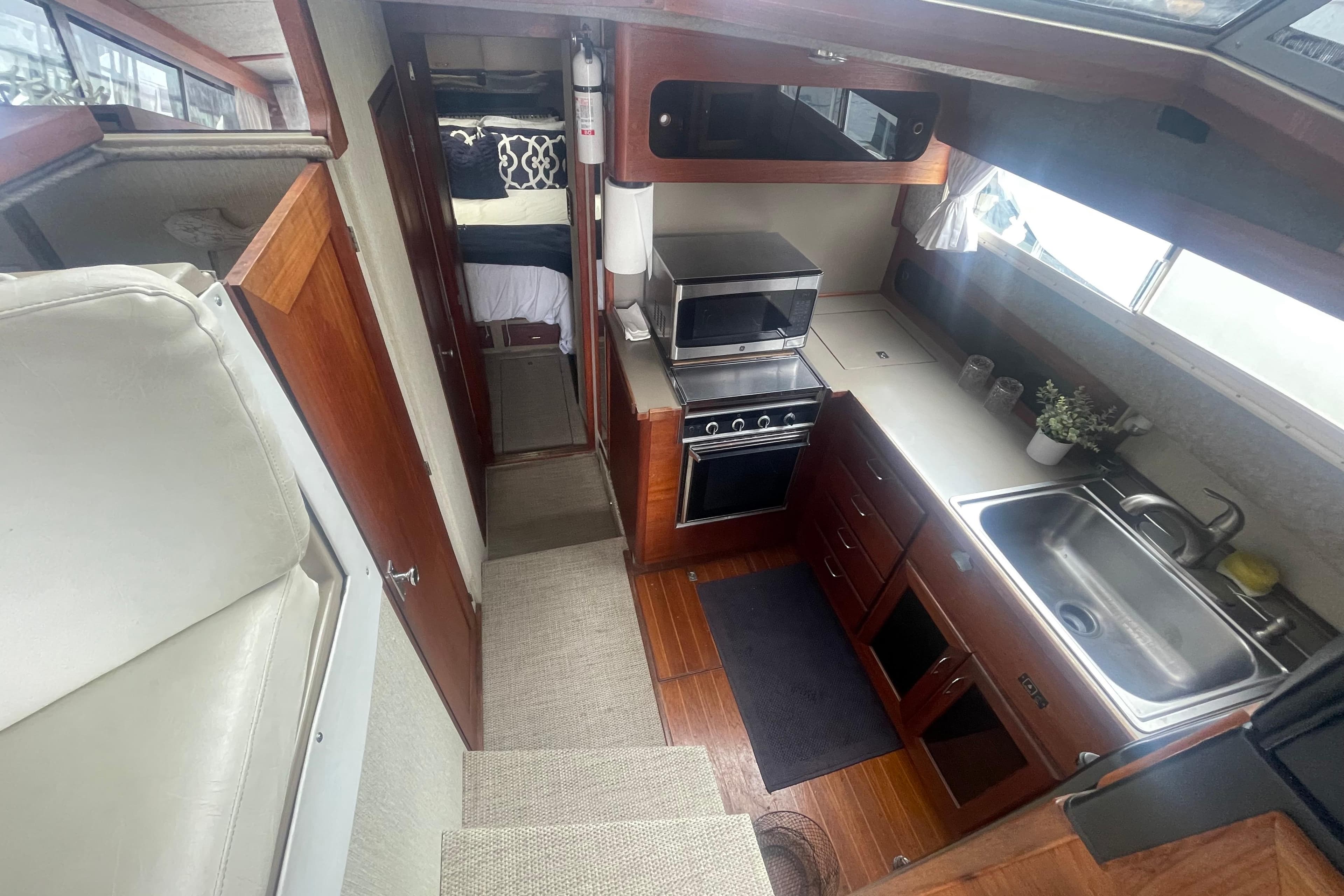 1983 Bayliner 3888 MY Sedan interior with kitchen, stove, sink, and cozy sleeping area.