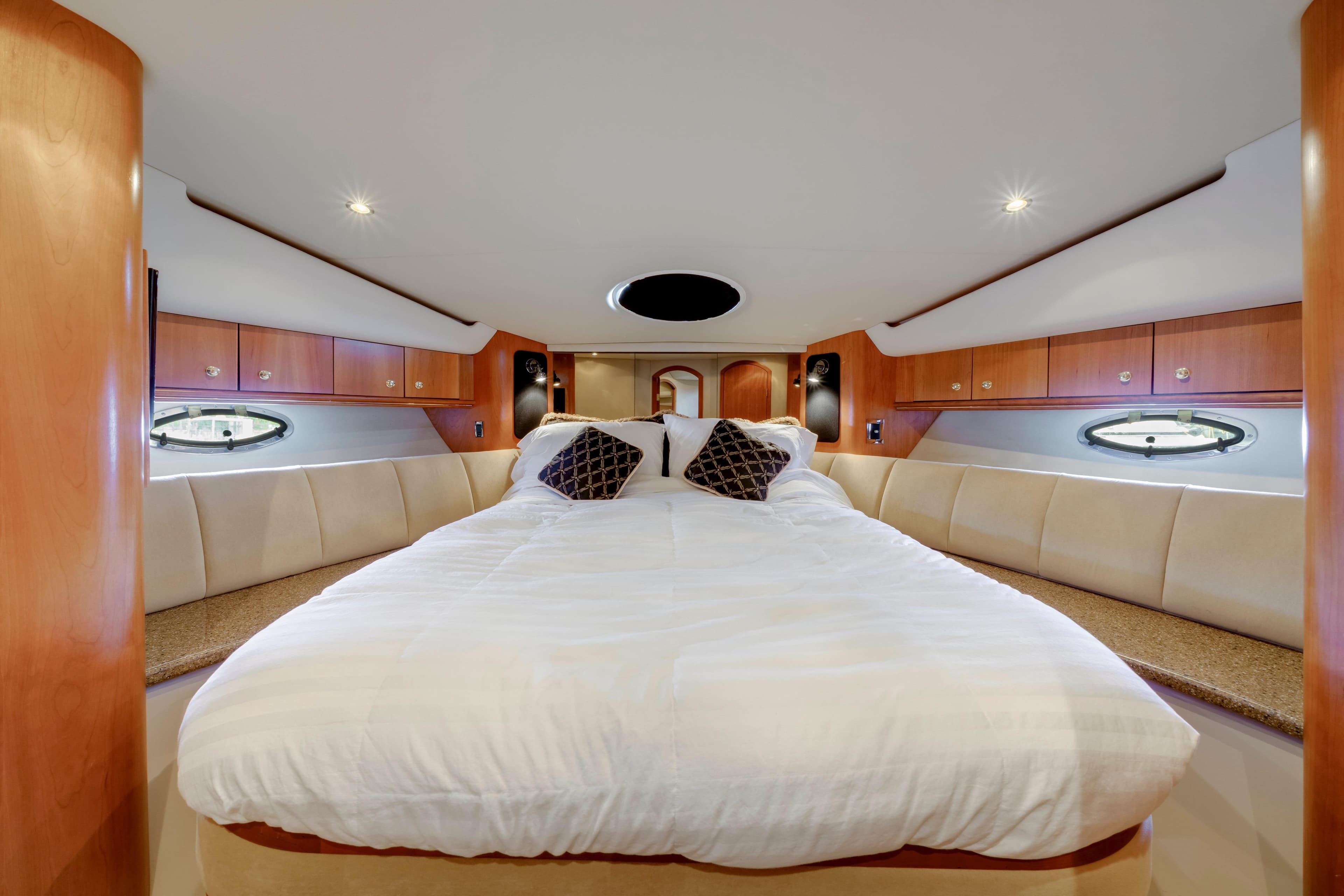 Luxurious bedroom interior of 2001 Cruisers Yachts 5000 Sedan Sport with elegant wood finish.