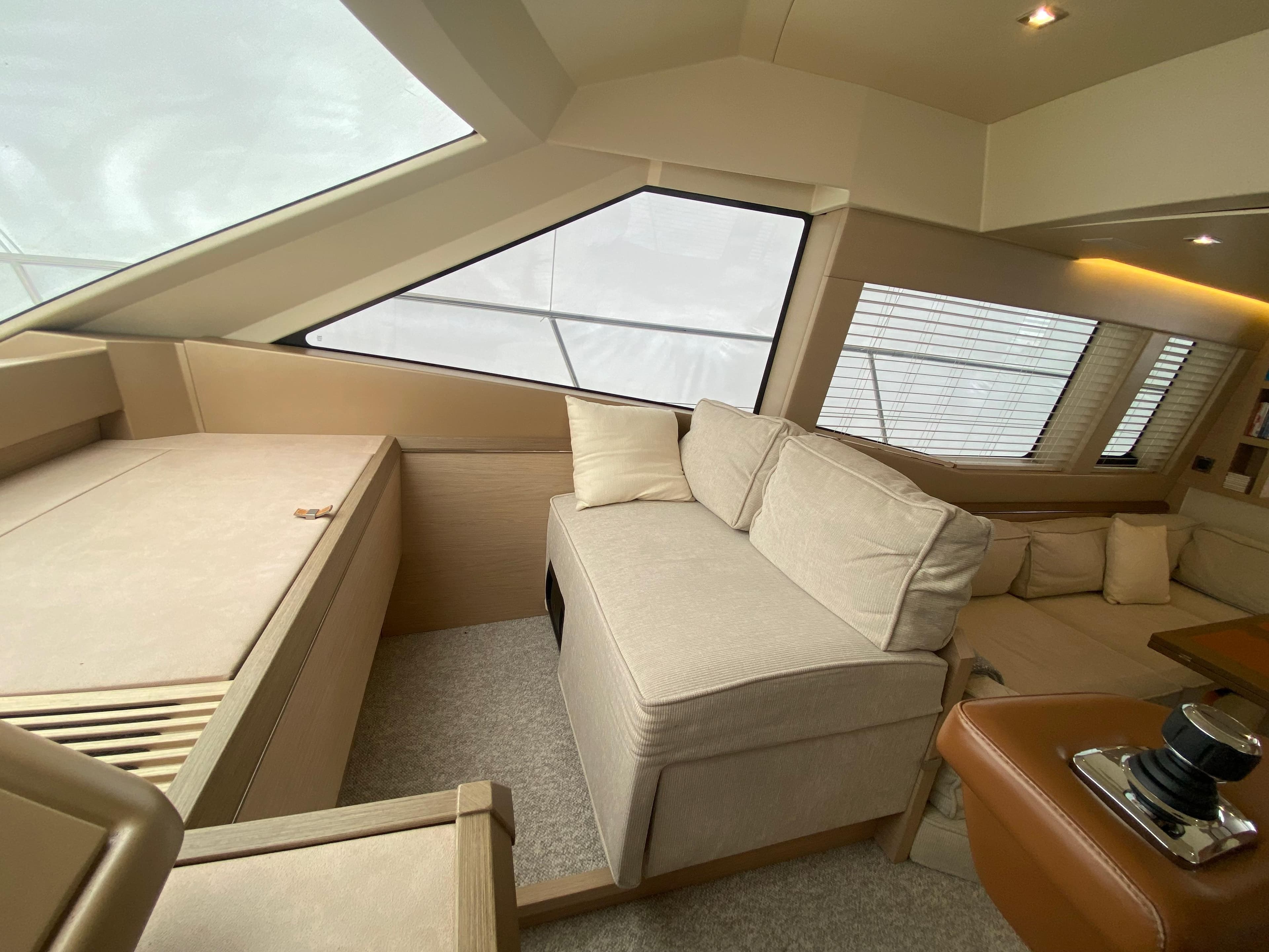 Luxurious interior of 2017 Beneteau Monte Carlo MC6 yacht with beige seating and large windows.