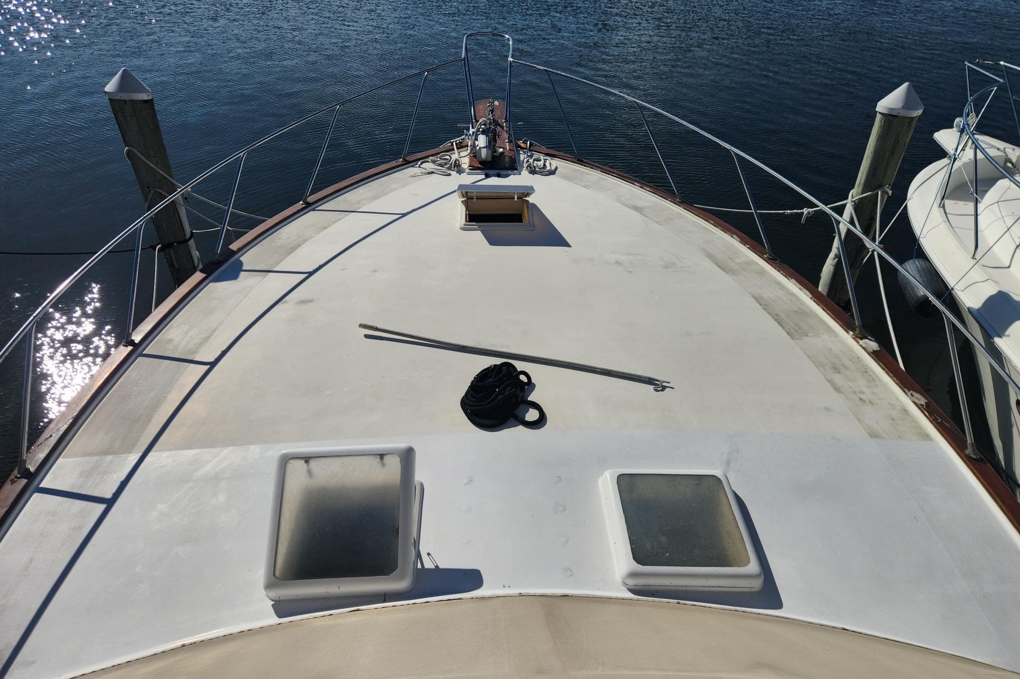 1977 Post Sport Fish boat deck with hatches, docked on calm water.
