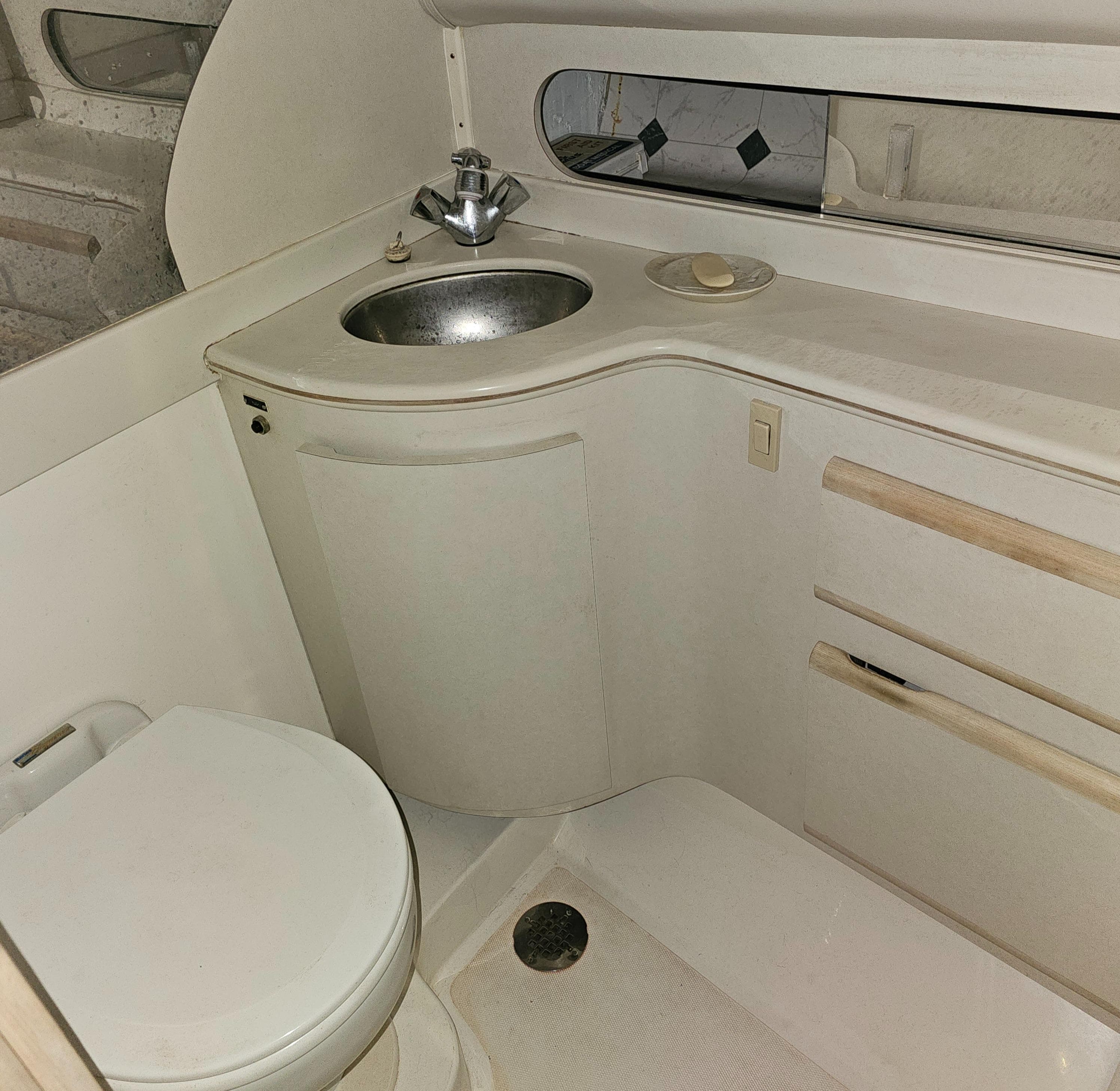 1994 Blackfin 33 Combi boat bathroom with sink, toilet, and storage cabinets.
