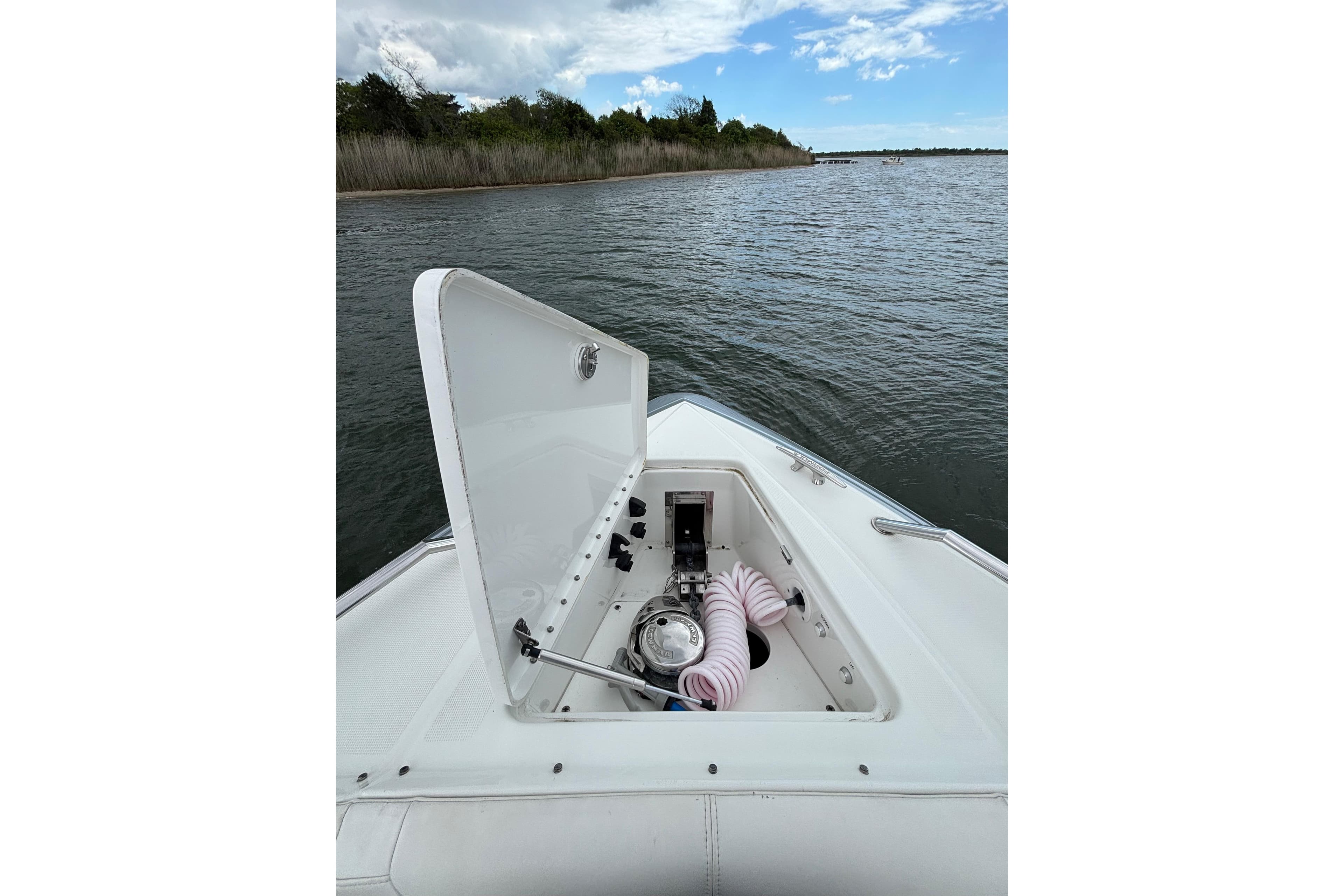 2017 Formula 430 Super Sport Crossover boat with open storage compartment on calm water.