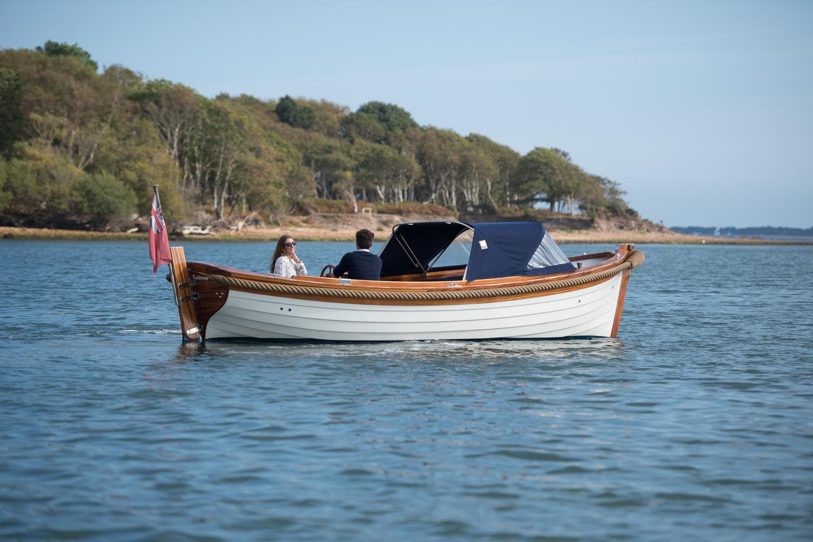 Barbaros 6.50 Launch boat, 2011 model, cruising on calm water near a wooded shoreline.