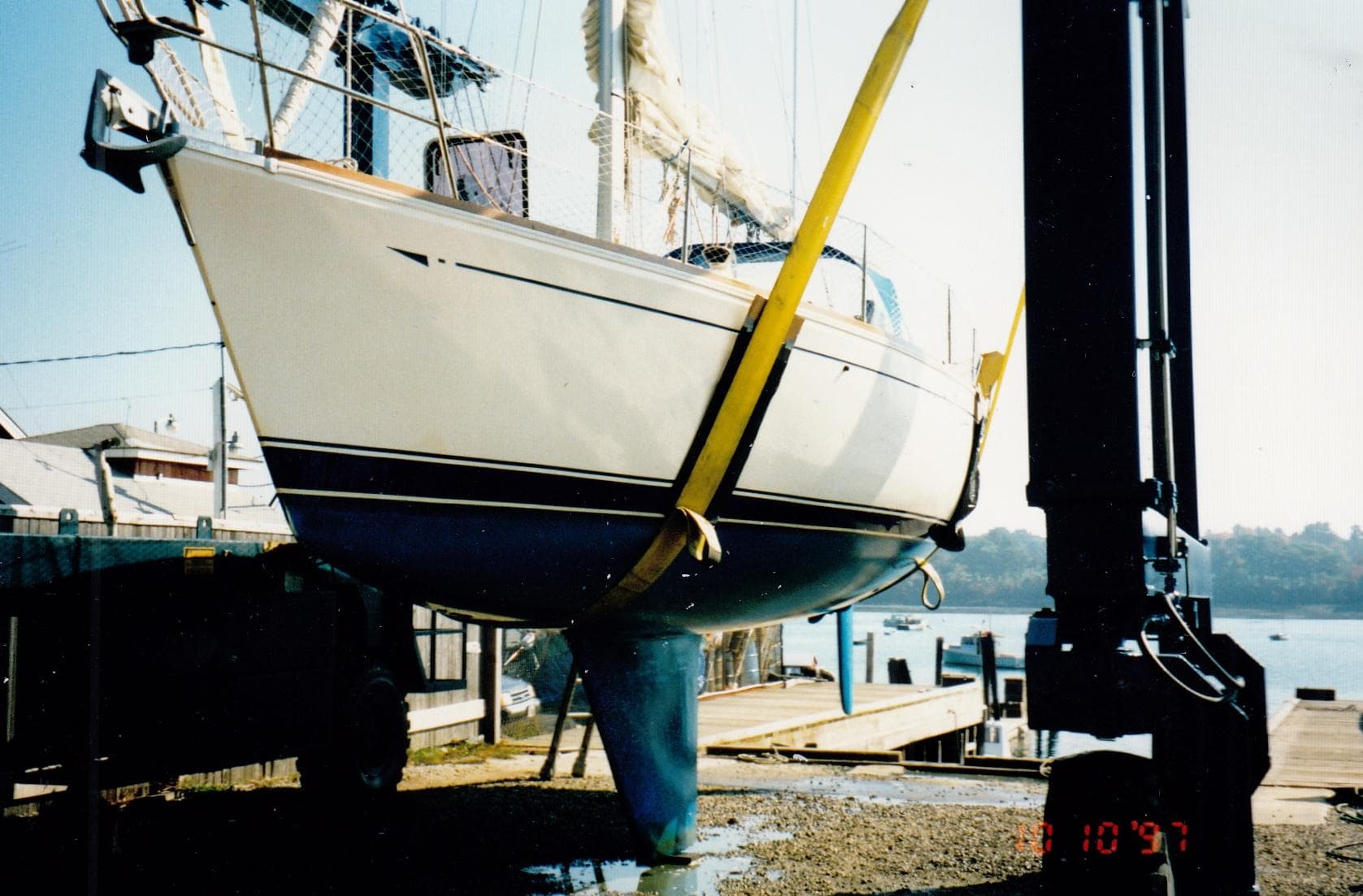 1988 CAL Sloop sailboat being lifted at a marina dock.