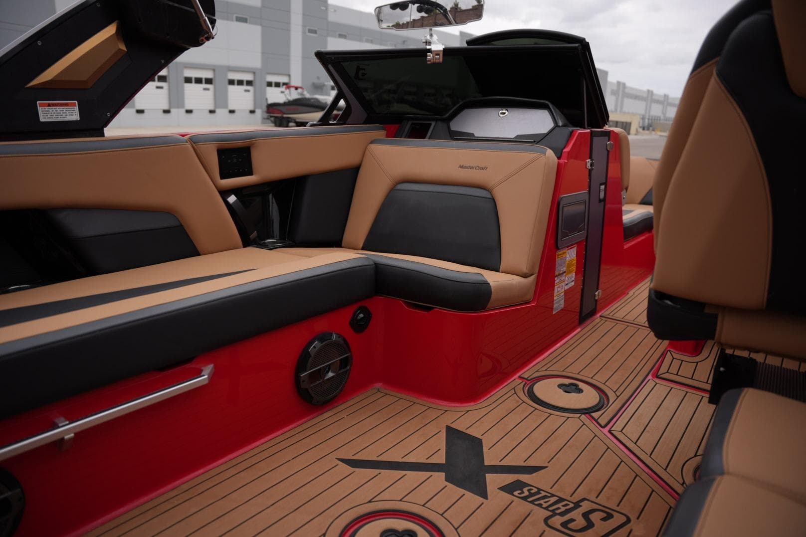 Interior of 2022 MasterCraft XStar S boat with tan and black seating, red accents.