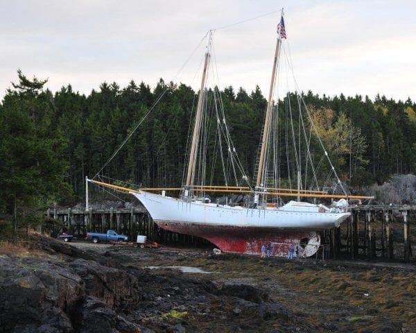 Schooner HARRIS and BISHOP 2006 on dry dock, surrounded by forested landscape.