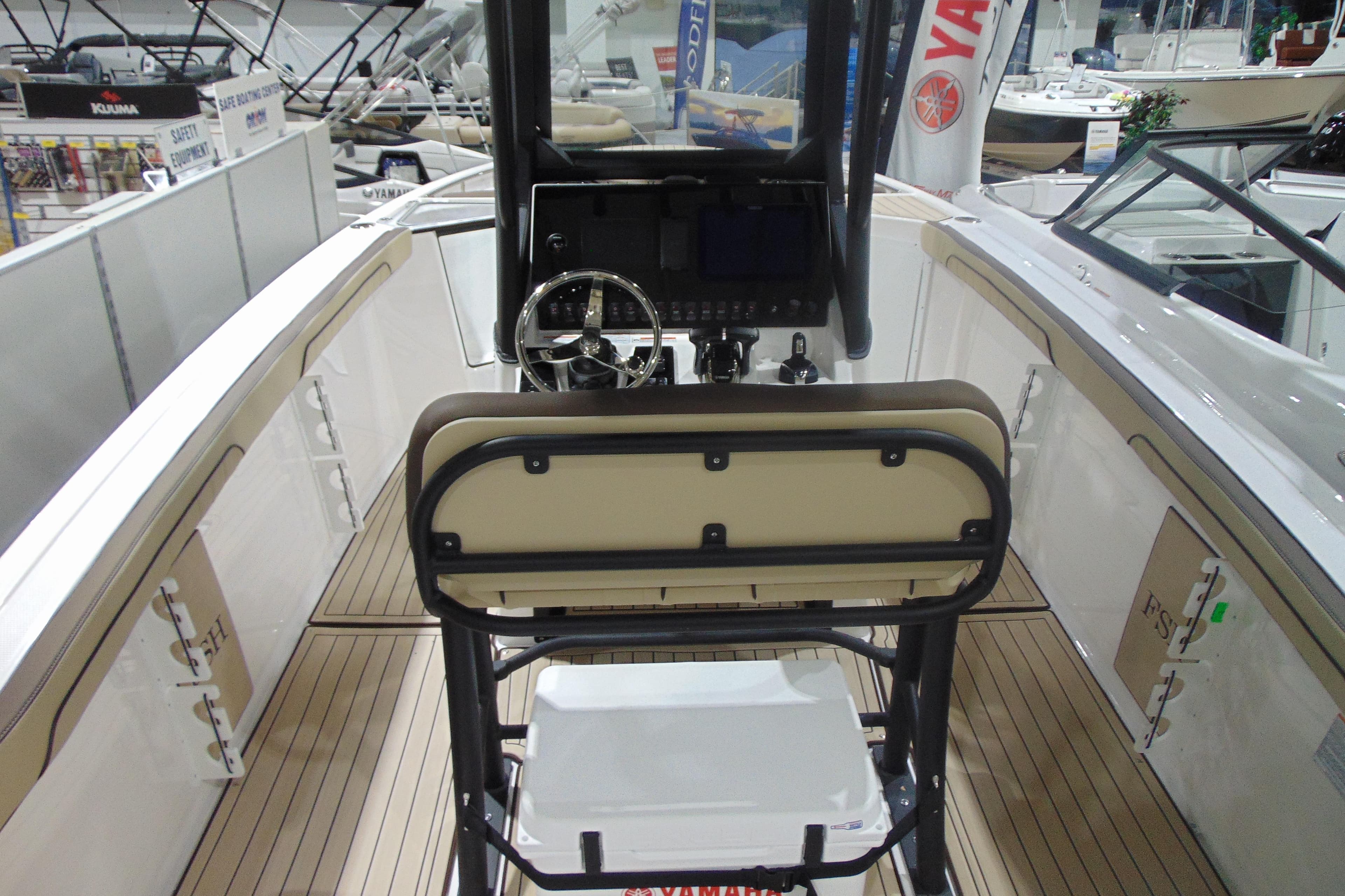 2026 Yamaha Boats 255 FSH Sport H interior with helm and seating, showcased at a boat exhibition.