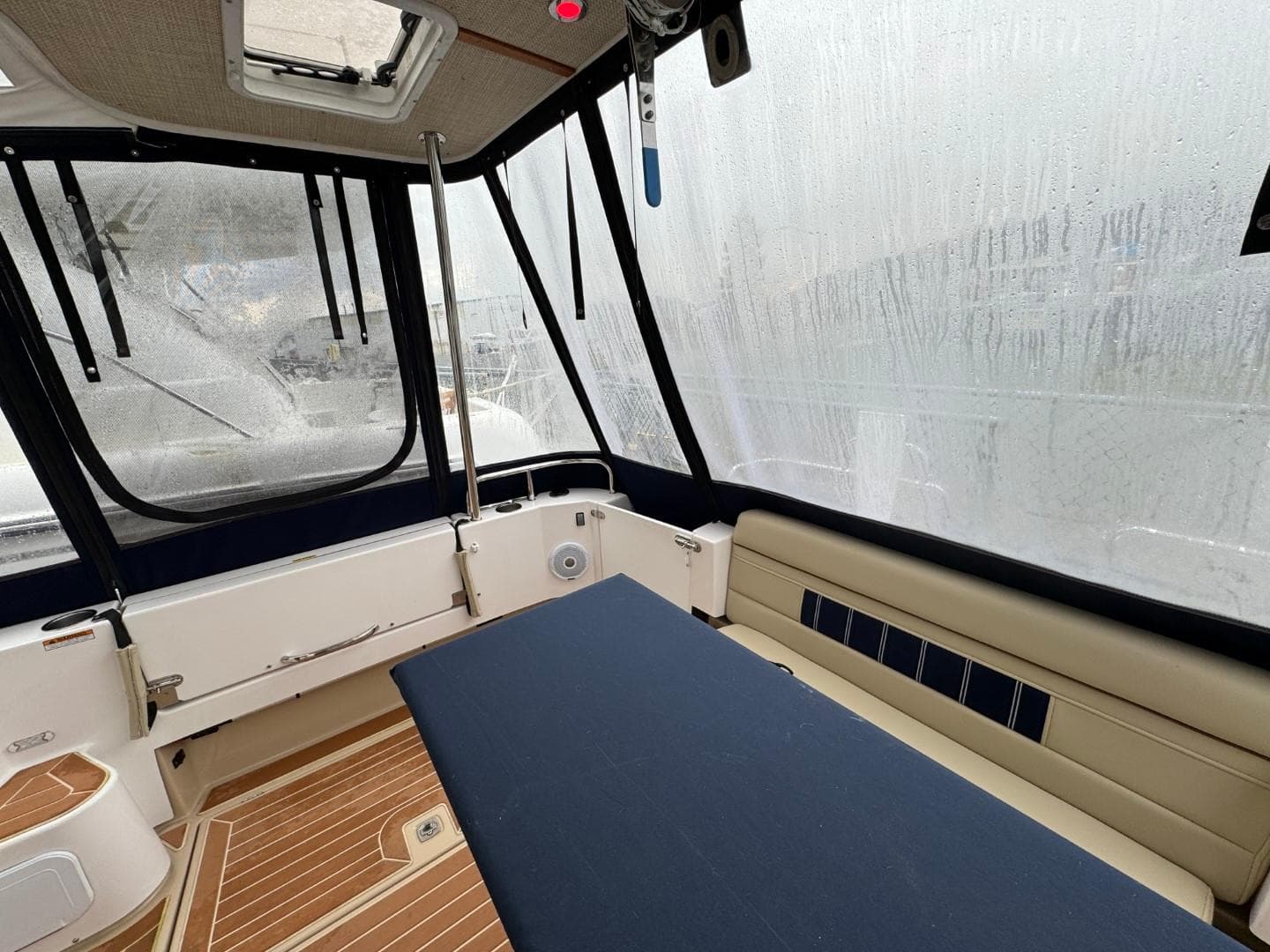 2018 Ranger Tugs R-31S Ranger Tug interior with seating and table, enclosed by windows.