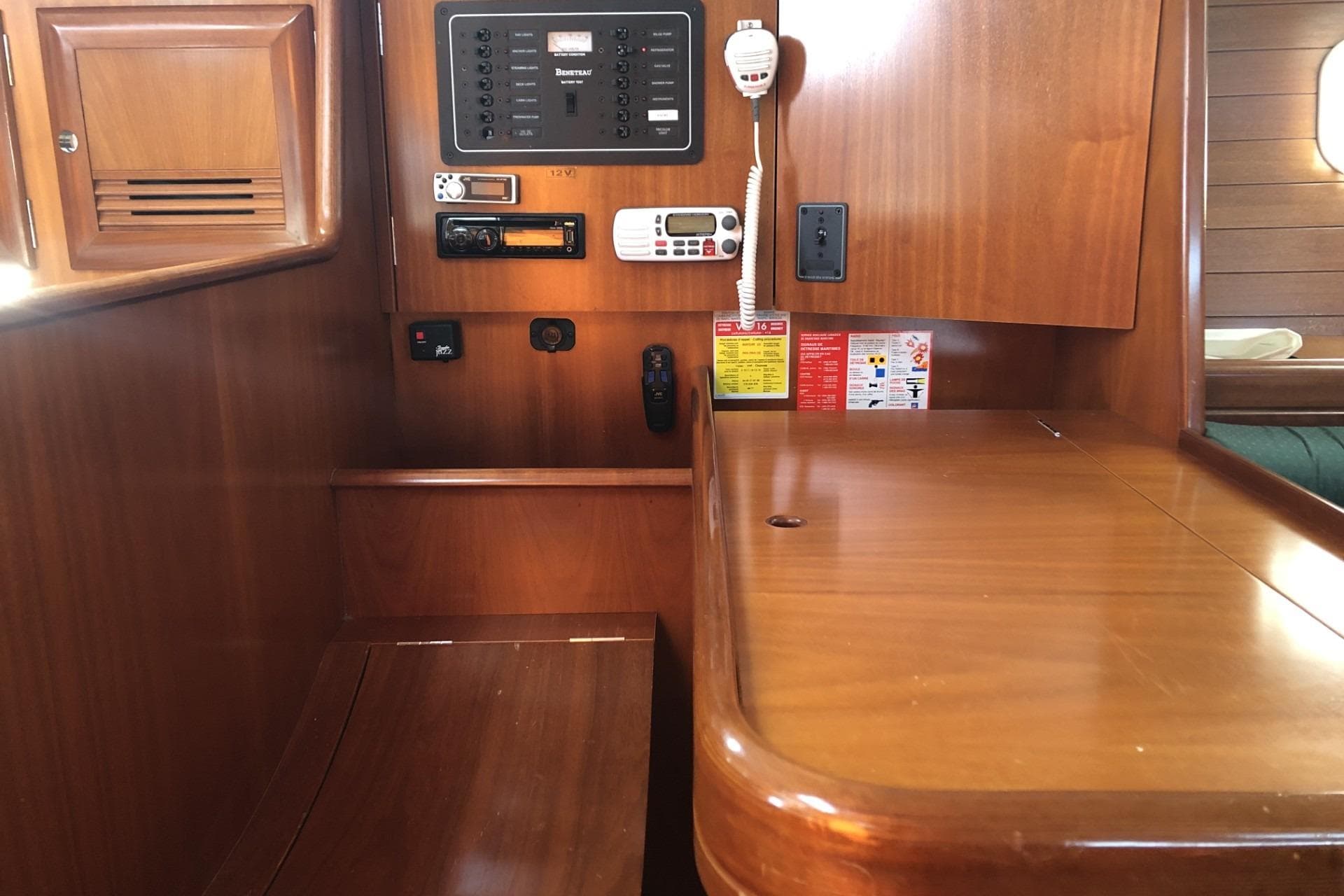 Interior view of 2001 Beneteau Oceanis 361 sailboat with navigation panel and wooden cabinetry.