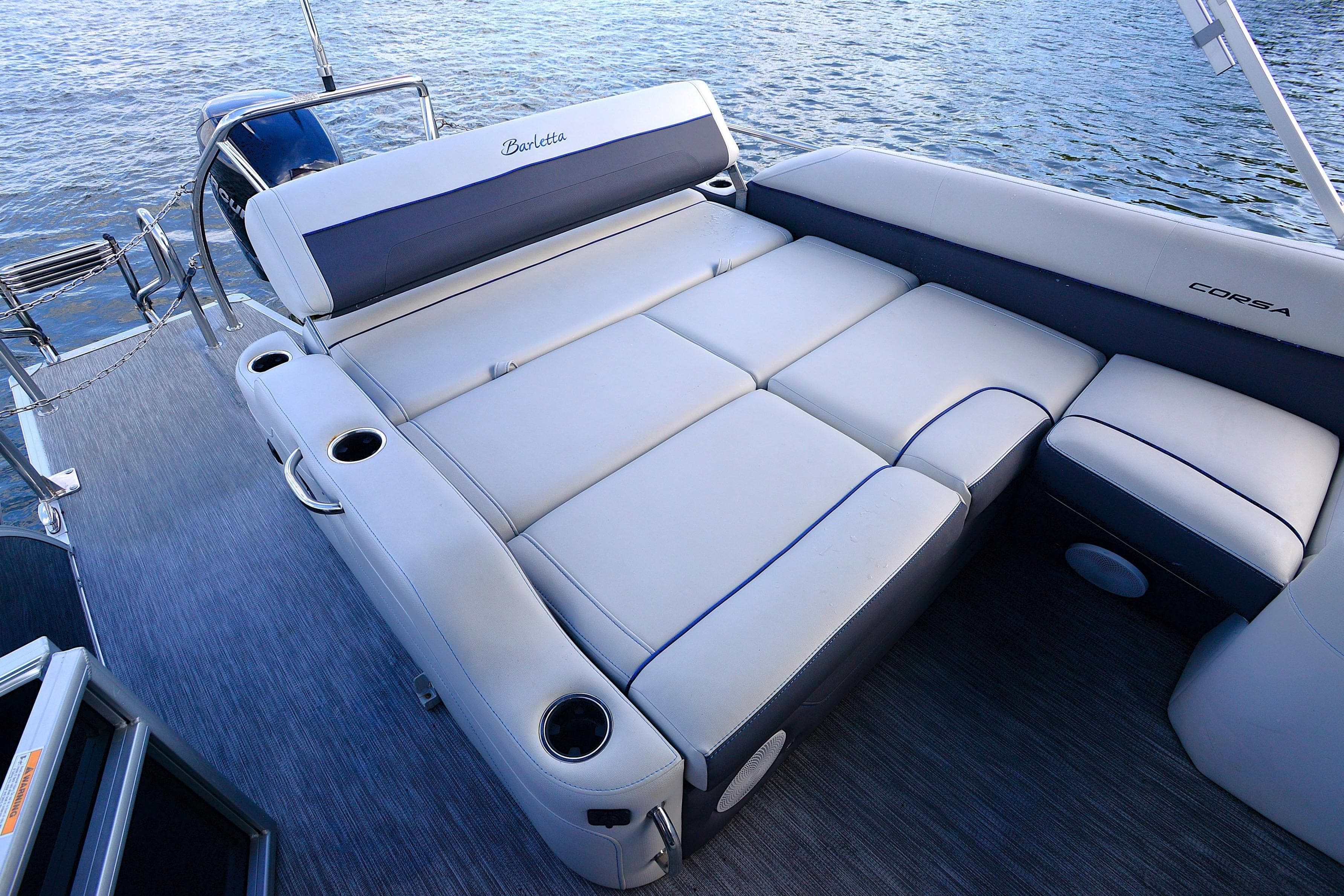 Luxurious seating on 2022 Barletta Corsa 25U pontoon boat, featuring comfortable cushions and cup holders.