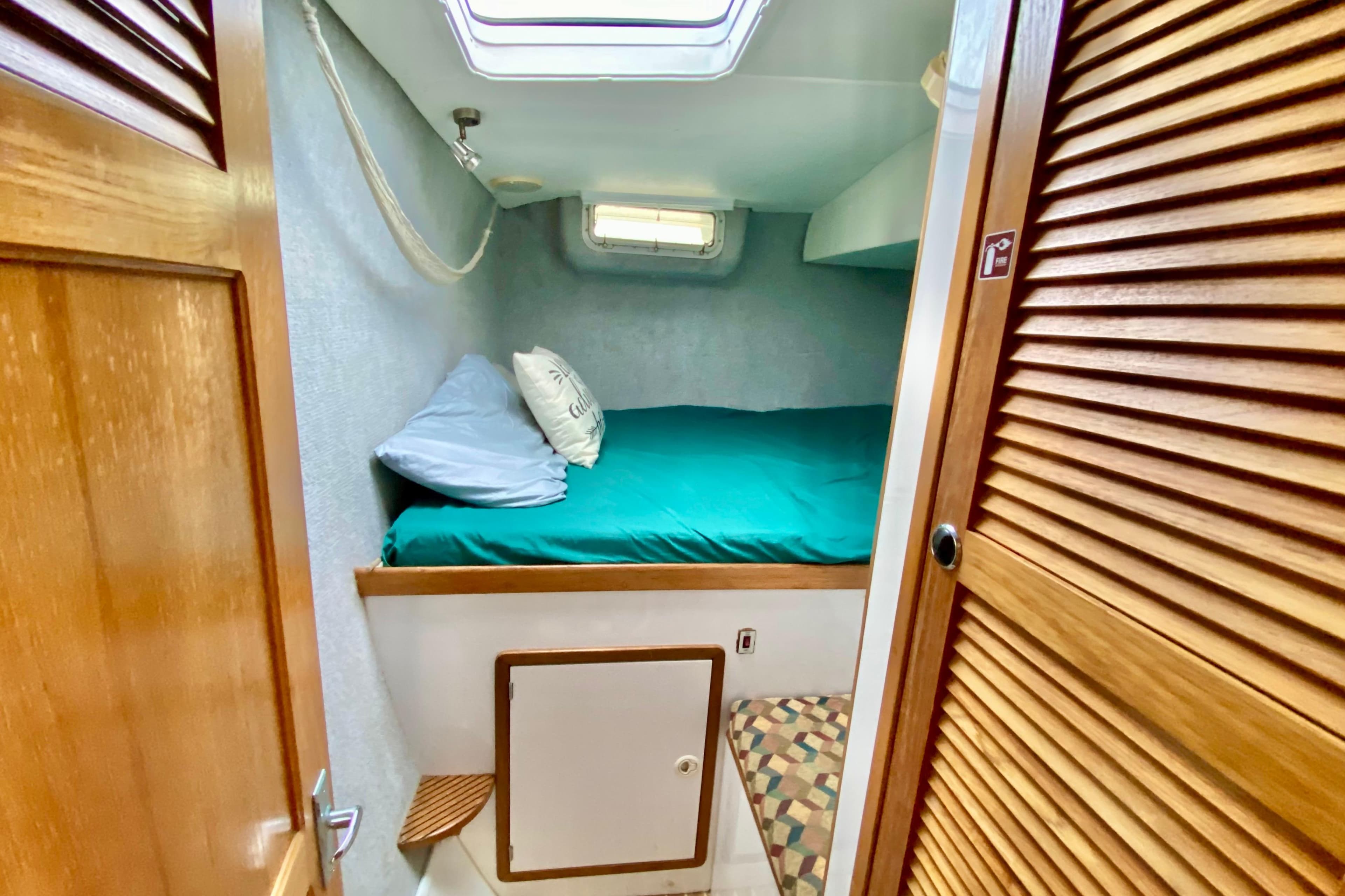 Cozy cabin interior of 1998 Manta 40 sailboat with bed and wooden accents.