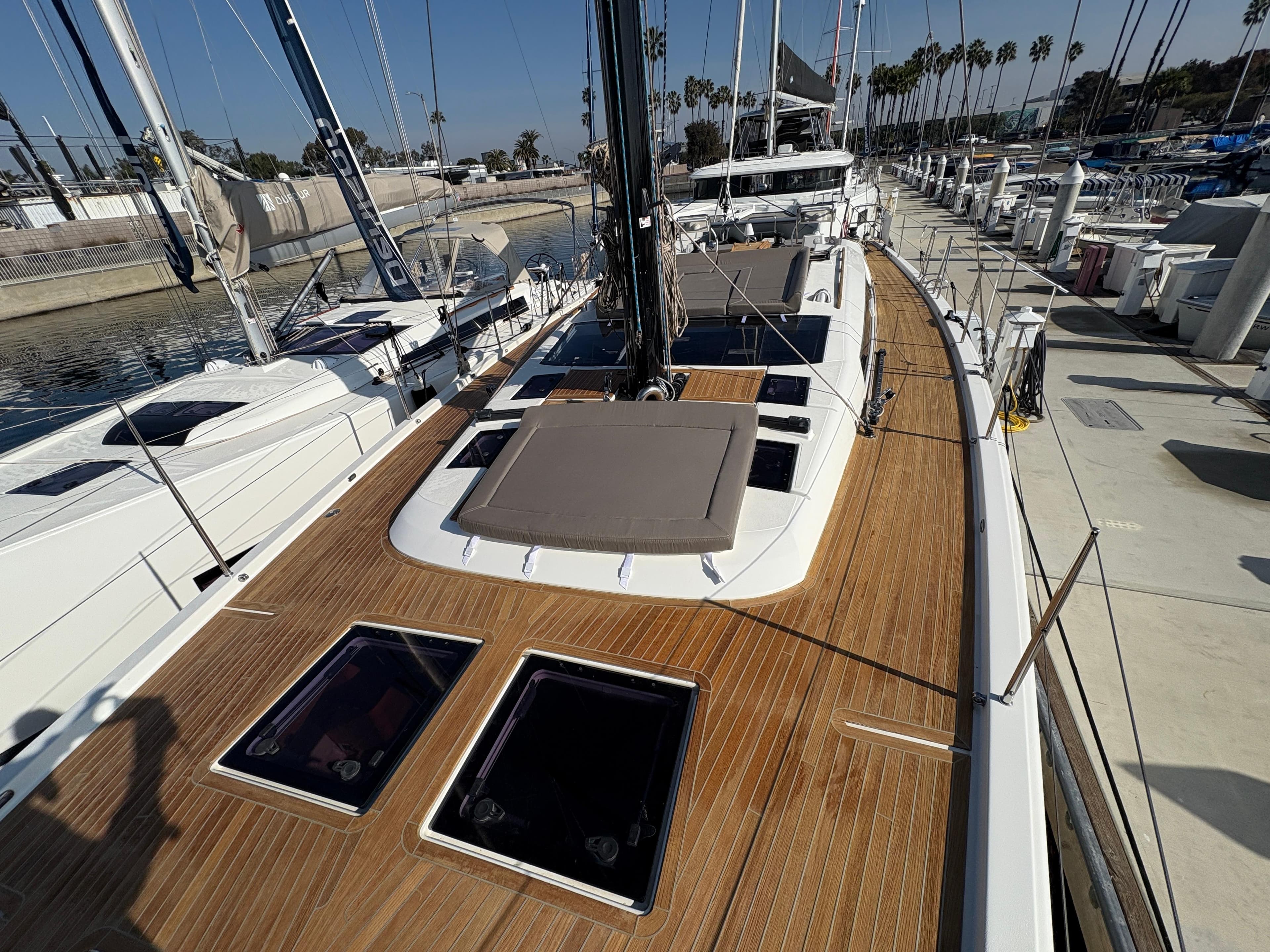 2018 Dufour 560 Exclusive yacht with teak deck, docked at marina.