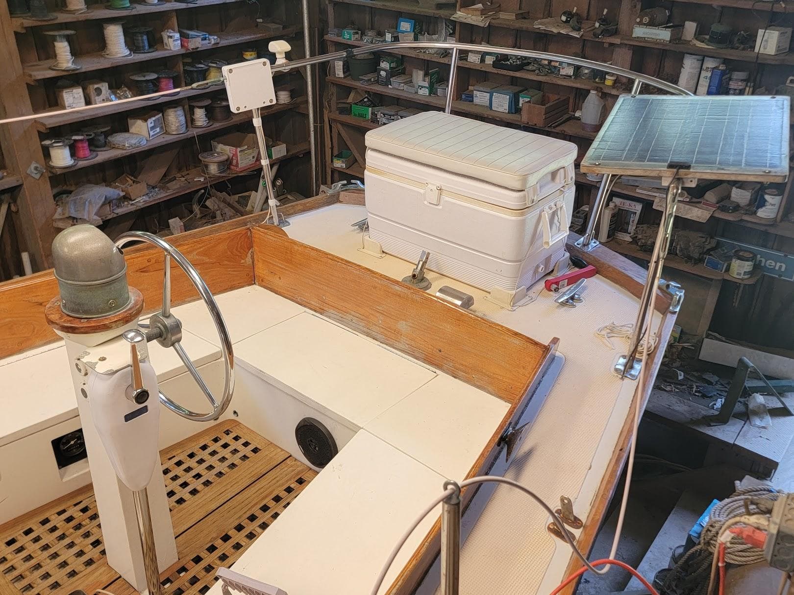 1968 Cheoy Lee Herreshoff 31 Offshore Ketch cockpit with steering wheel, cooler, and solar panel.