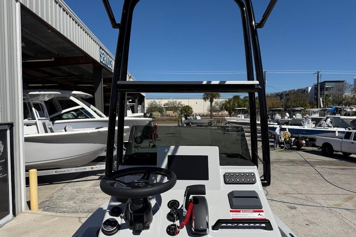 2026 SCB R24 boat console with steering wheel and controls, docked near other boats.