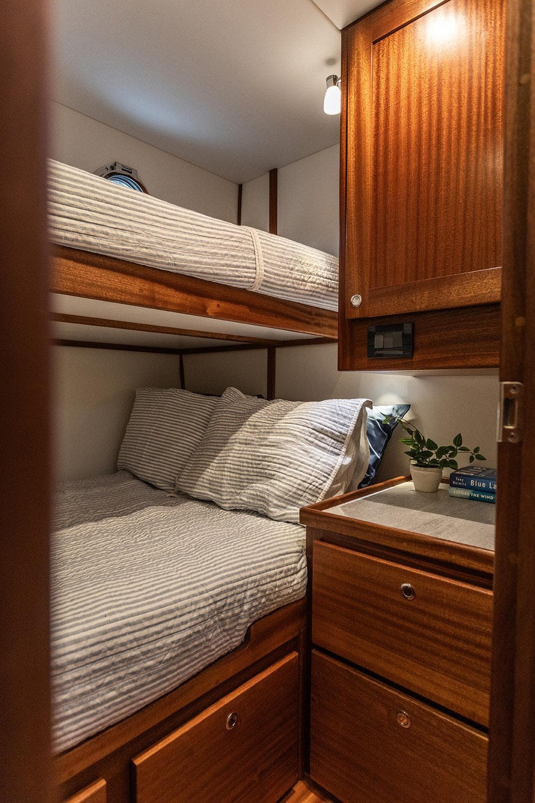 Cozy cabin interior of 2026 American Tug 395 with wooden furnishings and bunk beds.