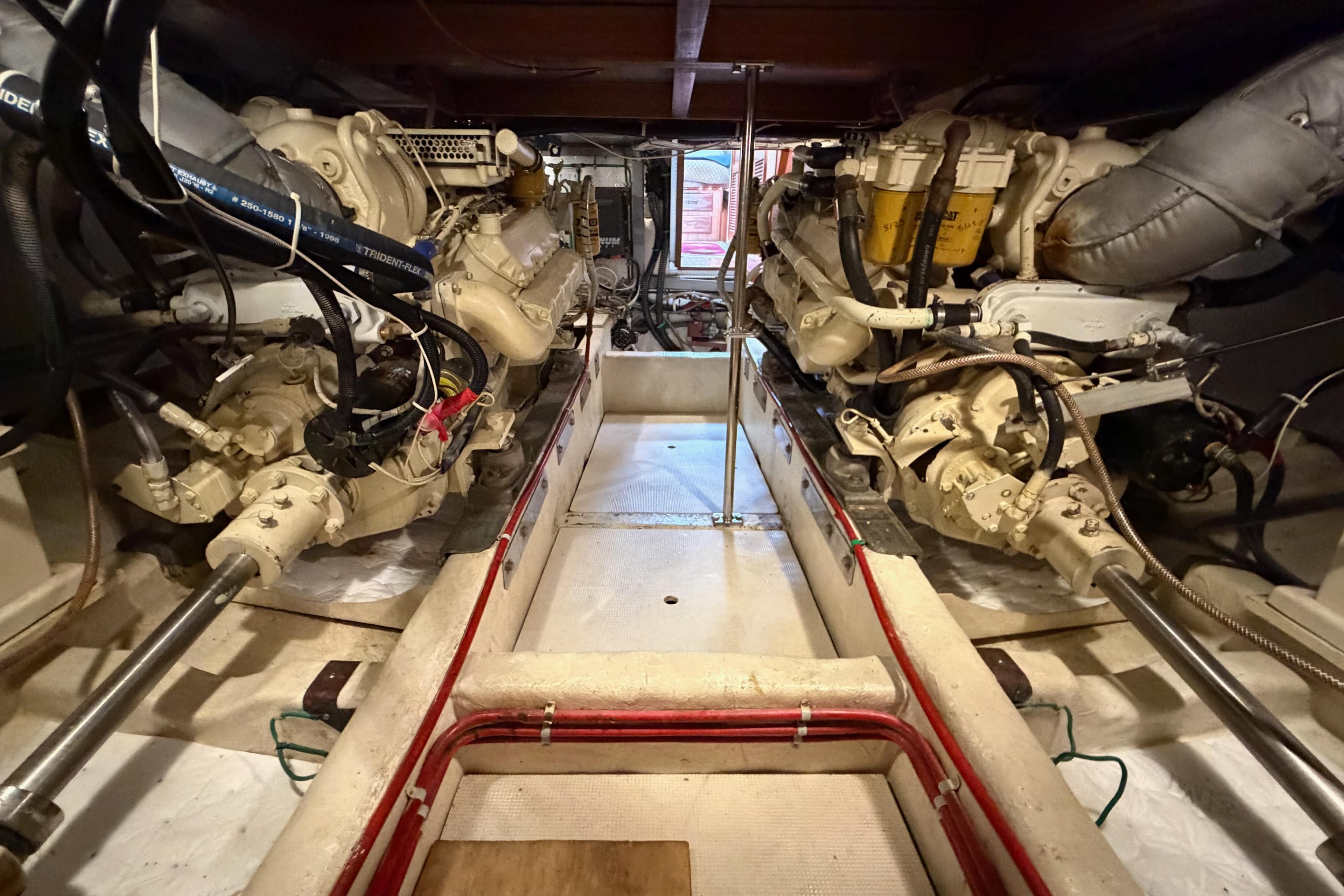 Engine room of 1988 Offshore Yachts 48 Sedan, showcasing dual engines and mechanical components.