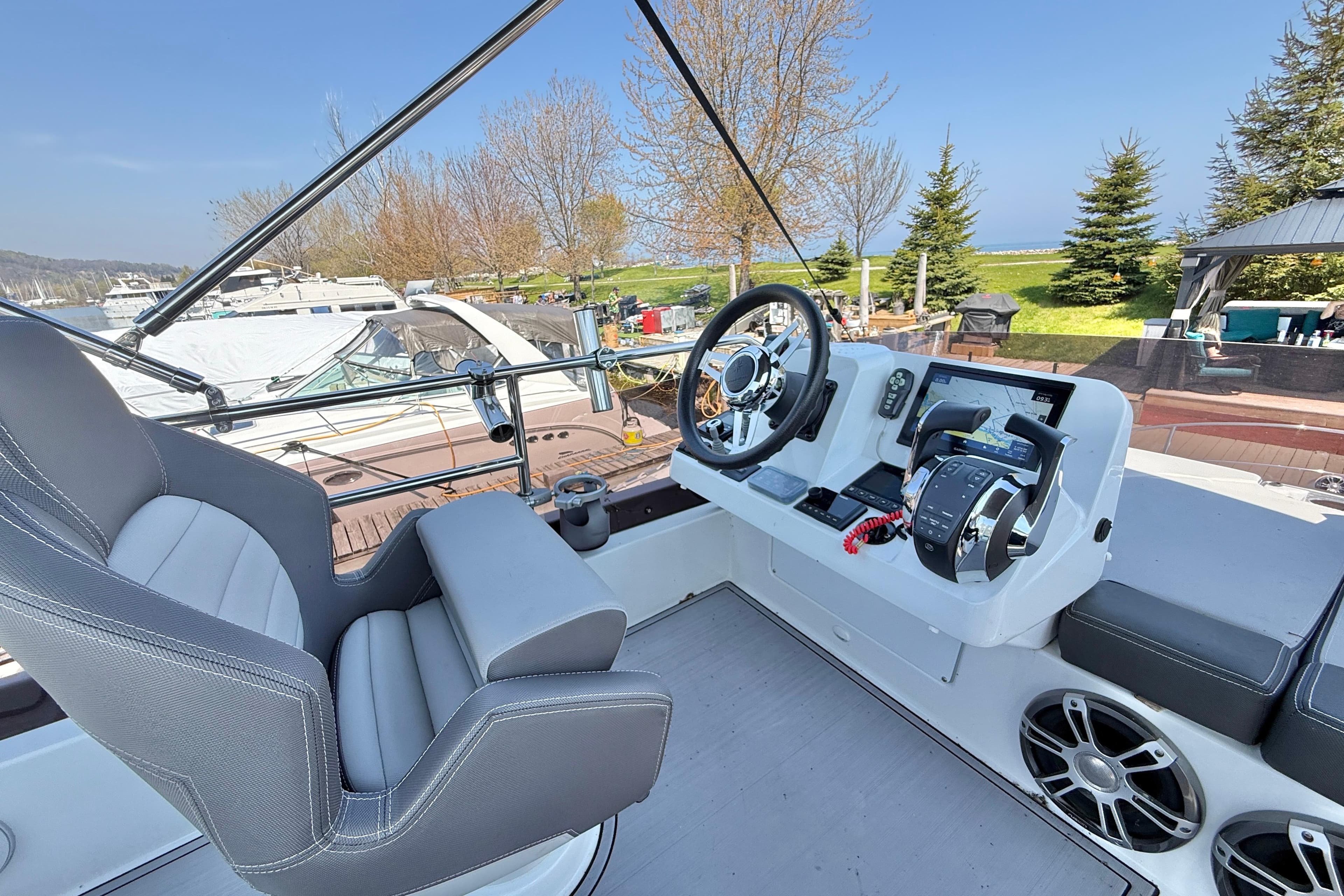 Flybridge helm of 2022 Jeanneau NC 1095 Fly with modern controls and seating.
