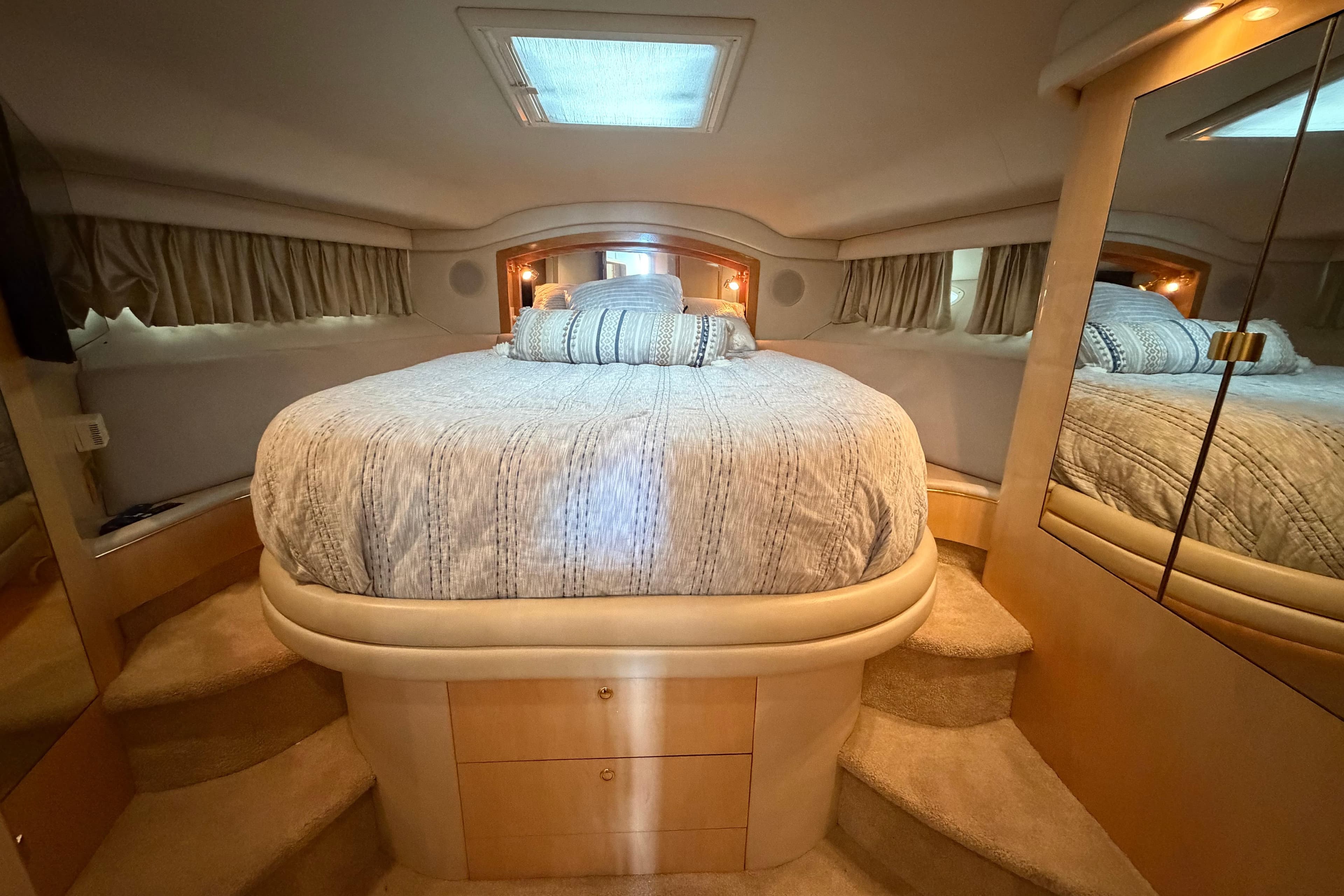Luxurious bedroom interior of 2000 Sea Ray 400 Sedan Bridge yacht with cozy bedding.