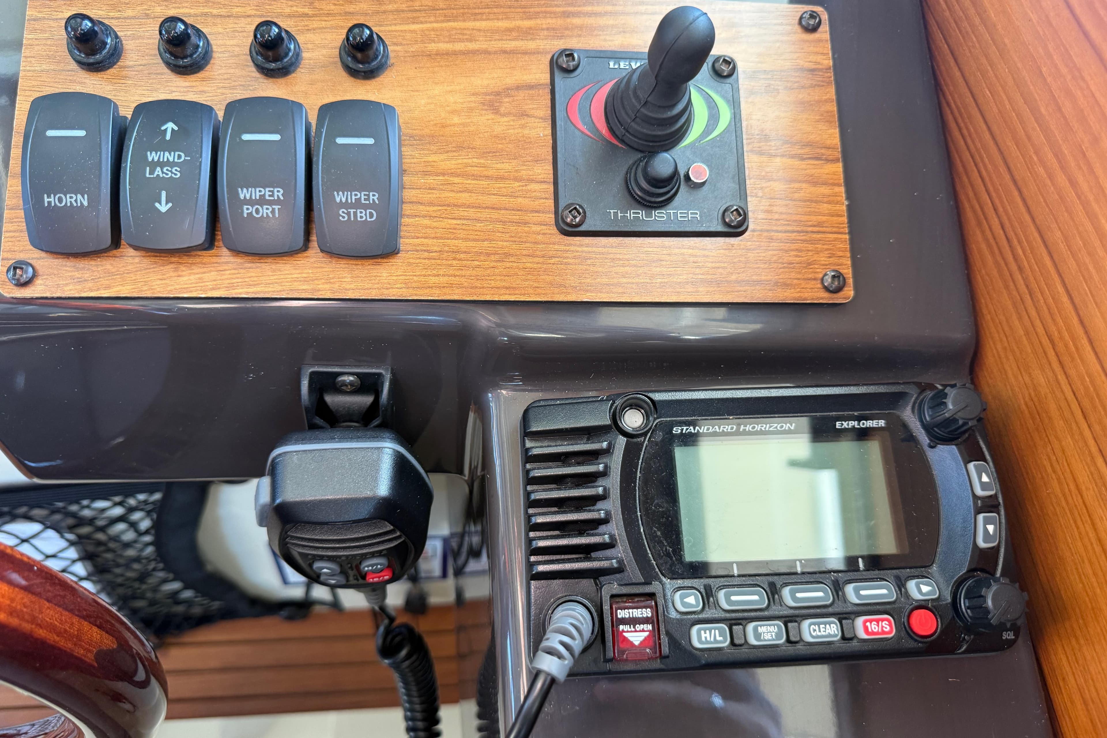 Control panel of 2022 Ranger Tugs R-27 with switches and marine radio.