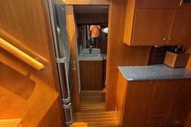 Interior of 2007 Island Pilot 395 yacht with wooden cabinetry and compact kitchen area.
