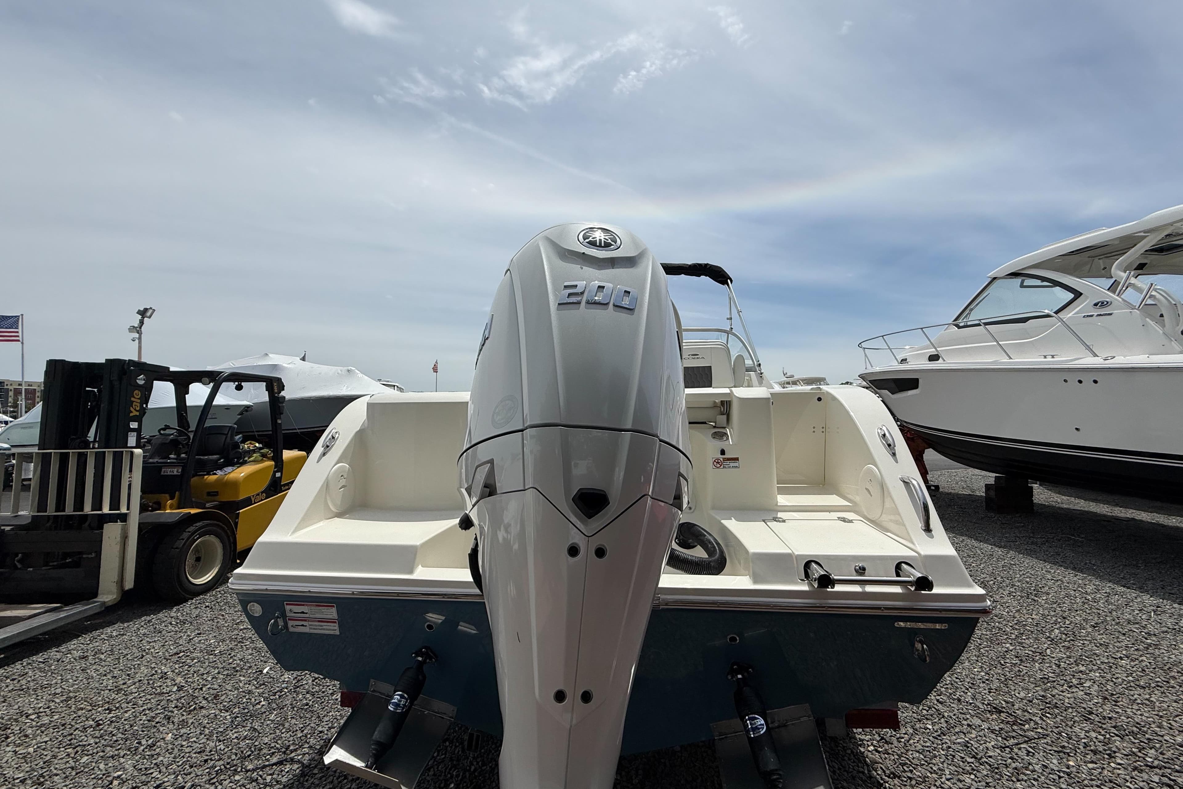 2025 Cobia 220 Dual Console boat with powerful outboard motor, displayed outdoors.