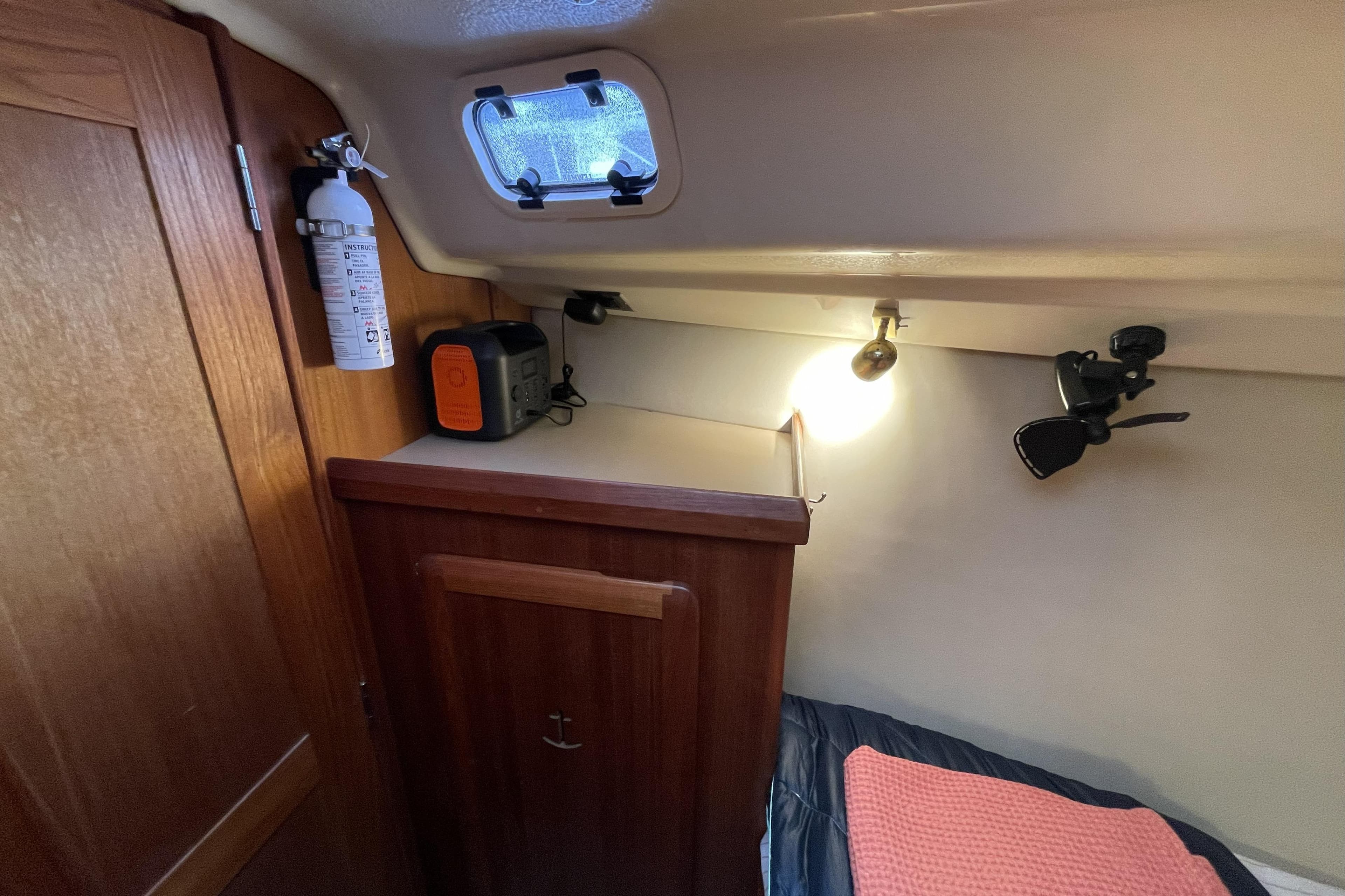Cozy cabin interior of 1992 Hunter 33.5 sailboat with storage and lighting.