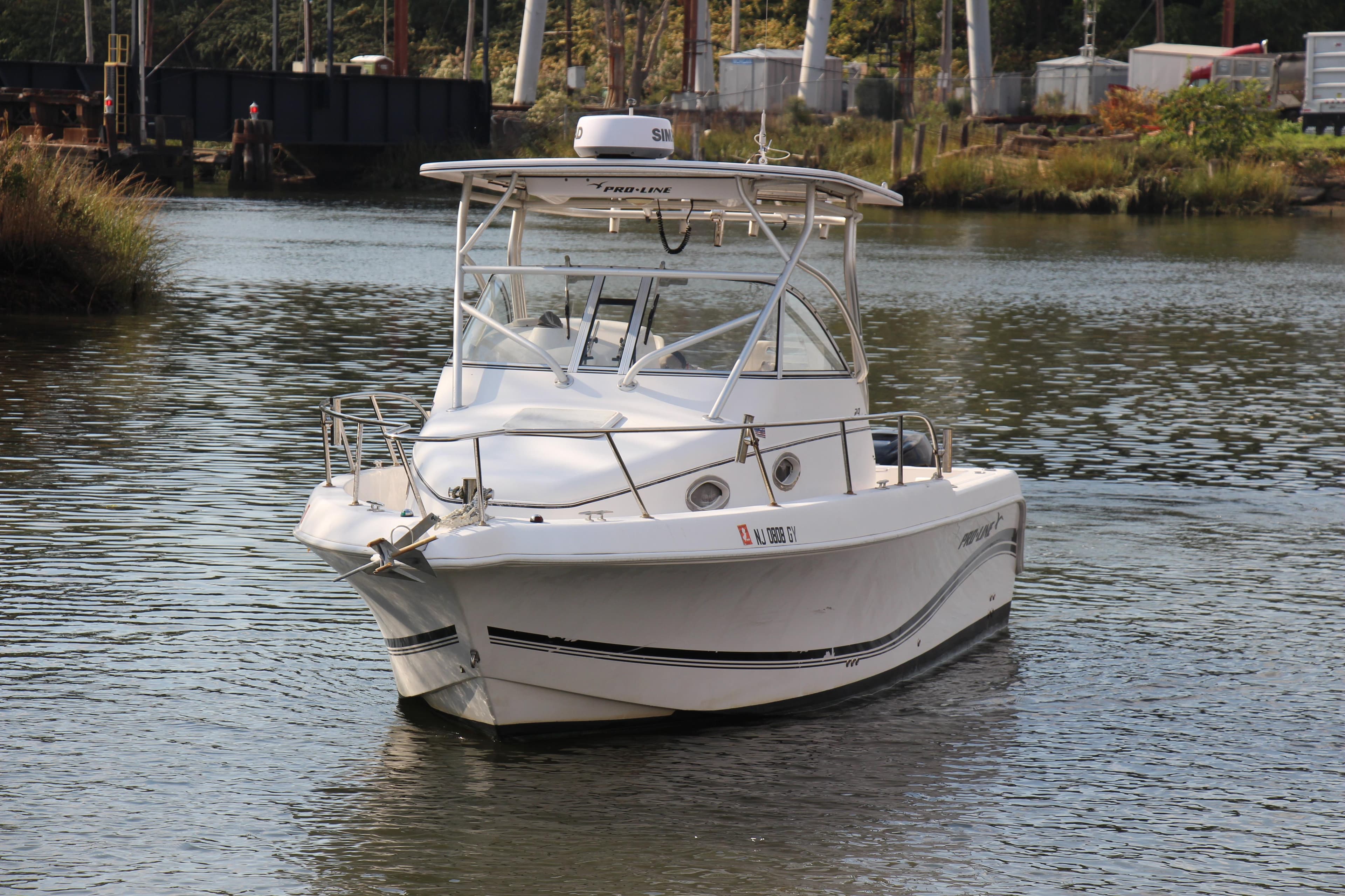2005 Pro-Line 29 Express boat navigating a calm river.