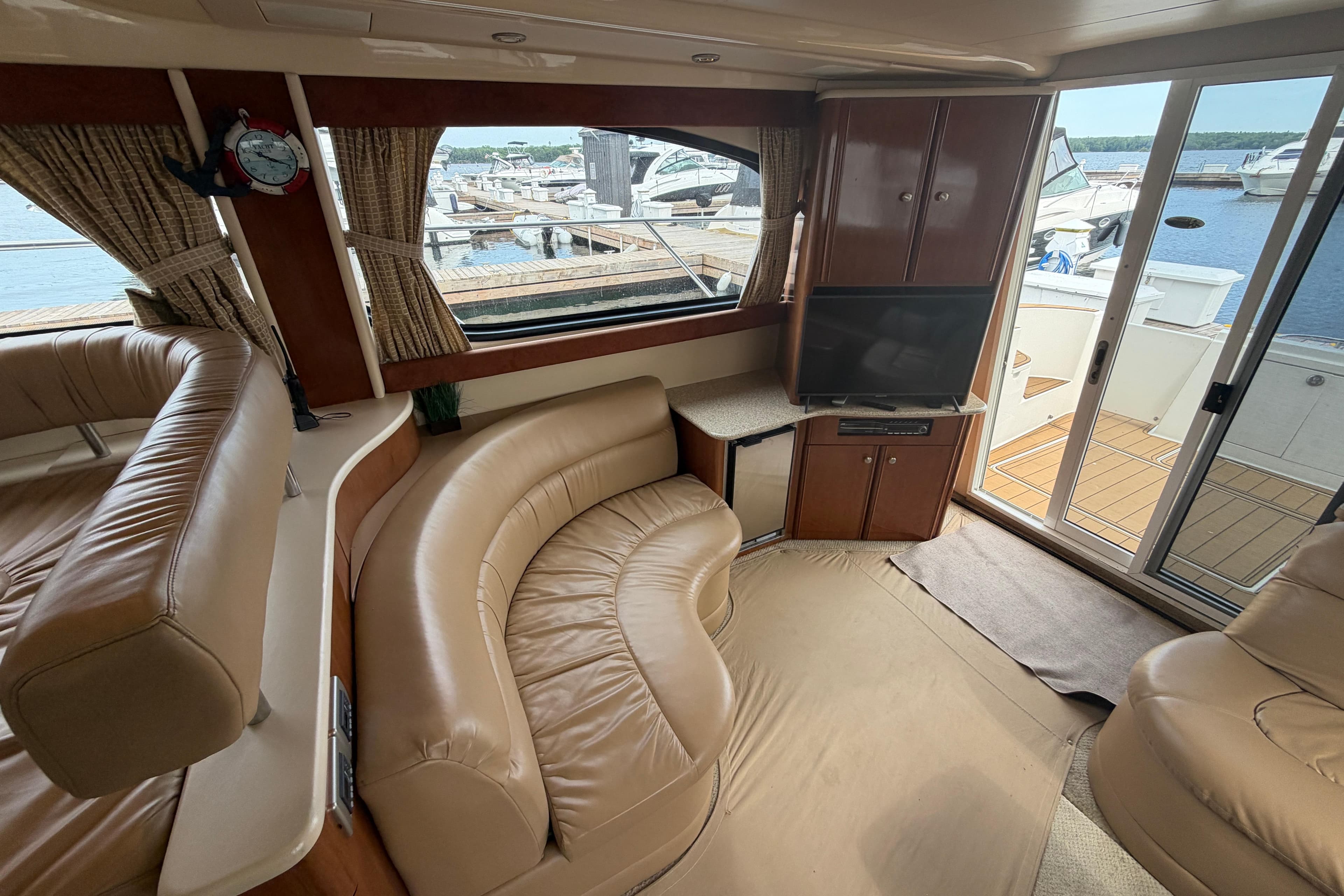 Luxurious interior of a 2006 Meridian 411 Sedan yacht with leather seating and waterfront view.