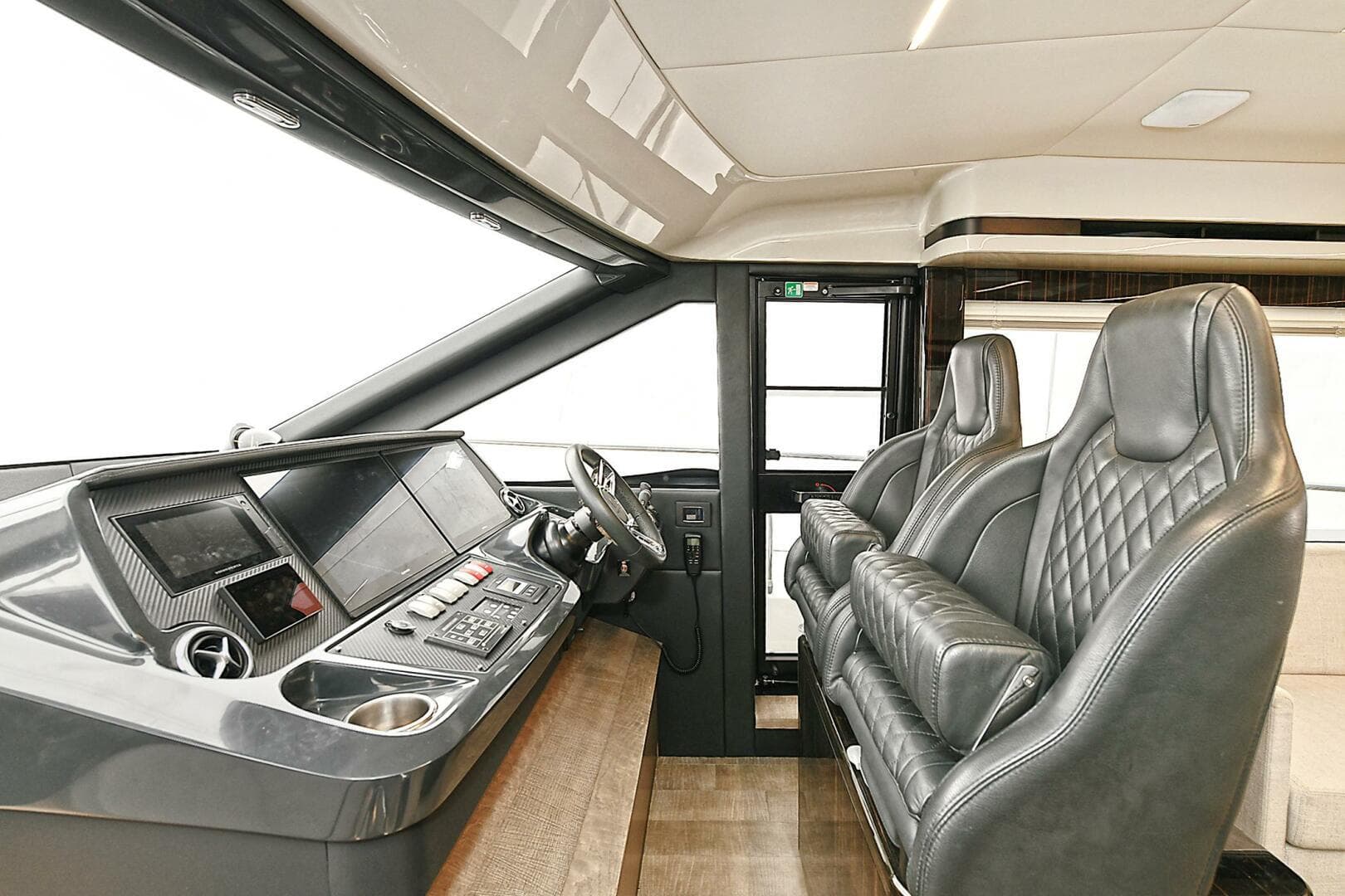 Luxurious interior of 2022 Absolute 62 Fly yacht with leather seating and modern dashboard.