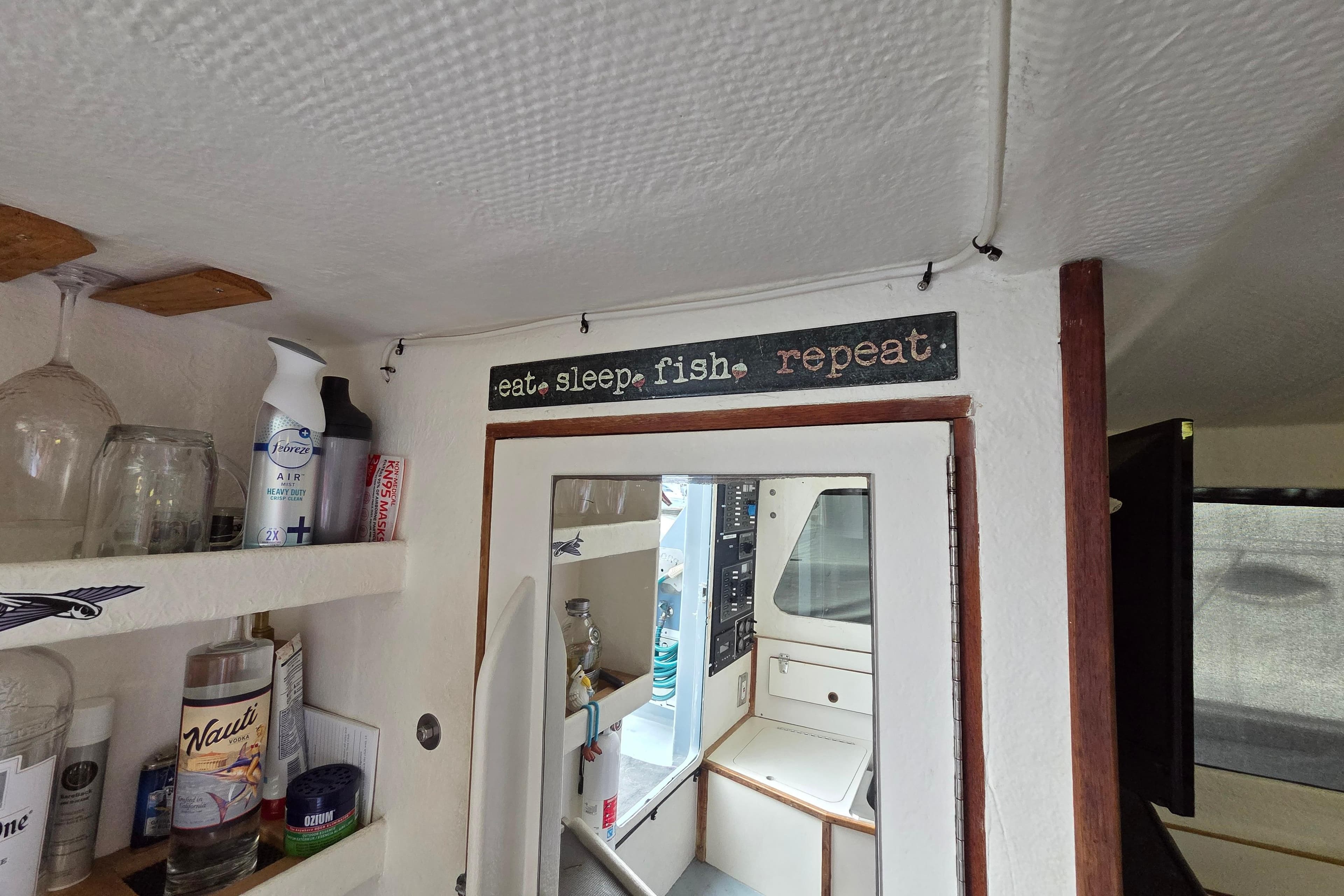 Interior of 1995 Custom 32 Branko Enclosed Bridge with "eat sleep fish repeat" sign.