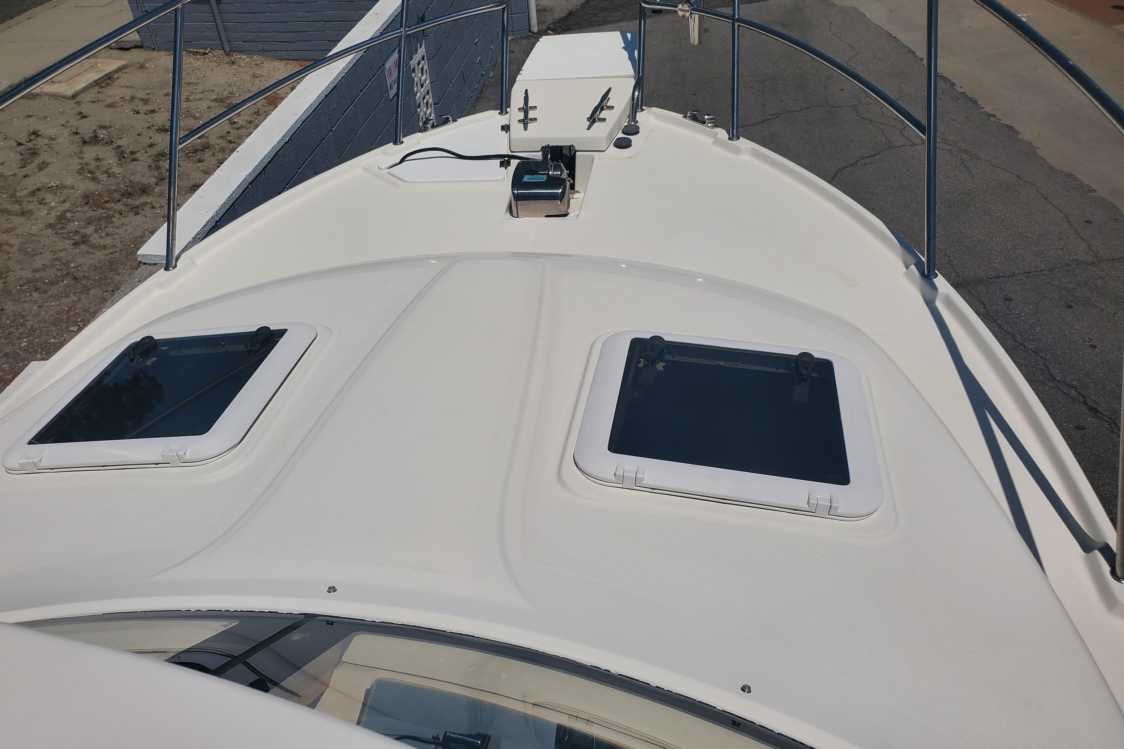 2013 Cutwater 26 boat deck with hatches and railing, viewed from above.