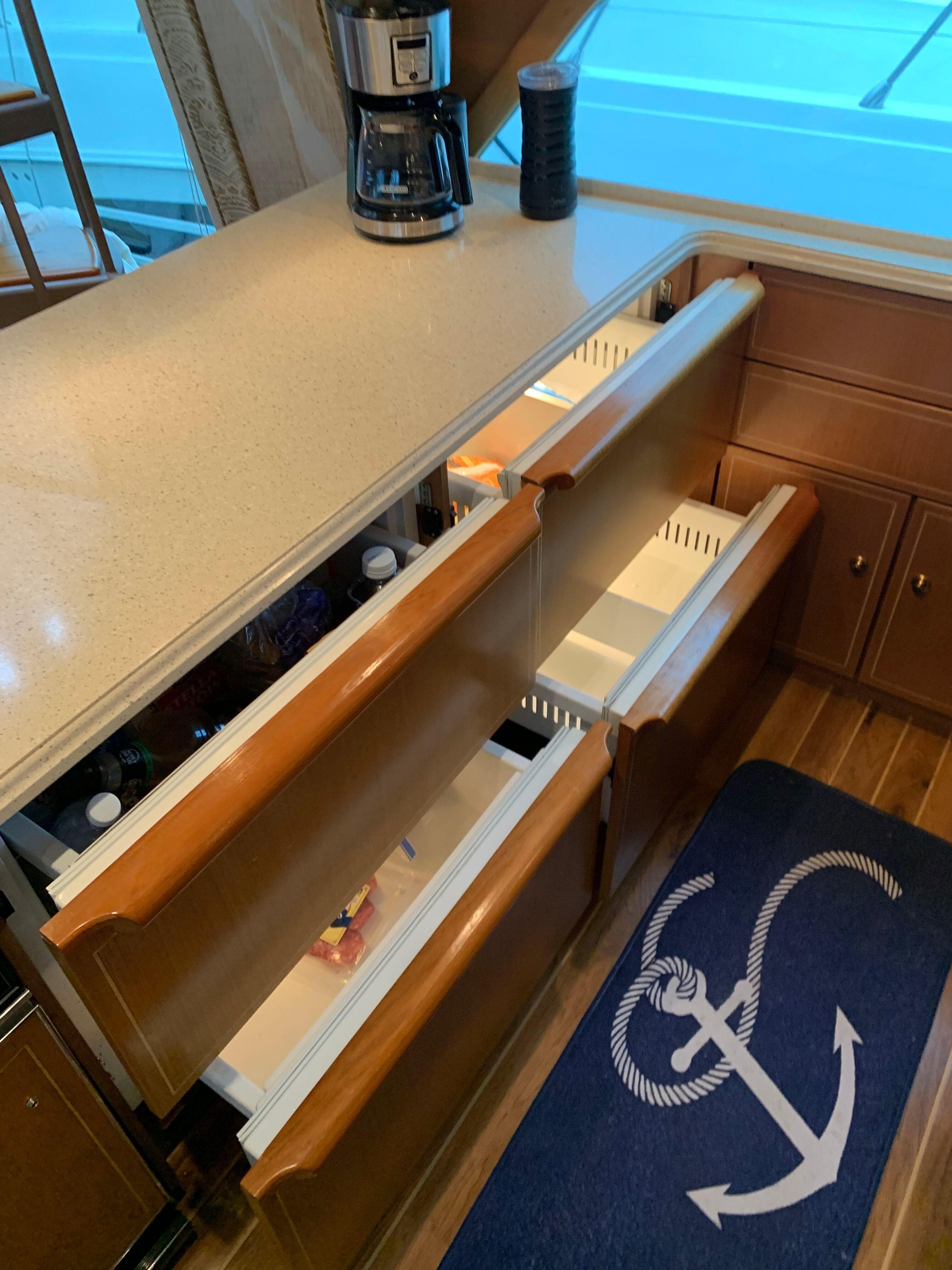 2004 Ocean Yachts 57 Odyssey kitchen with open drawers and anchor-themed rug.