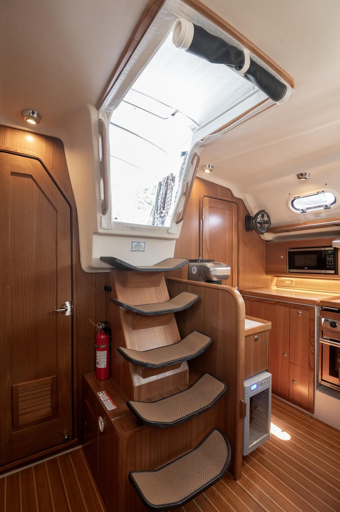2024 Catalina 445 yacht interior with wooden stairs and modern kitchen amenities.