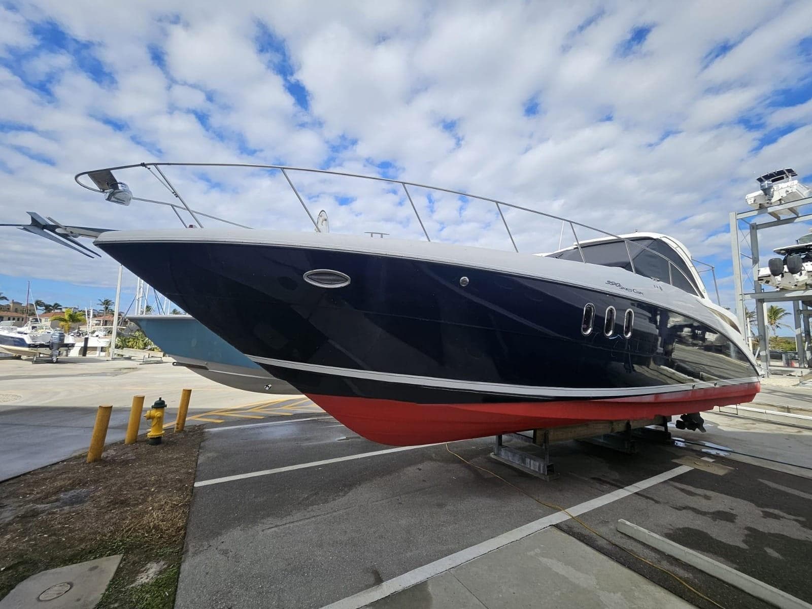 2008 Cruisers Yachts 390 Sports Coupe on dry dock under a partly cloudy sky.