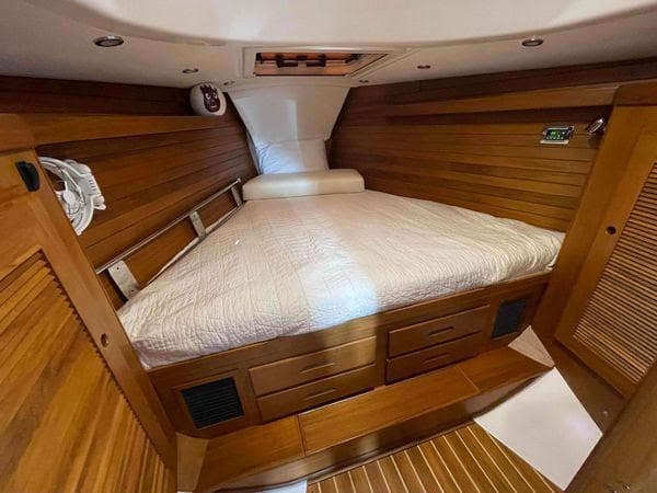 Luxurious cabin interior of 2020 Tartan 395 yacht with wooden finish and cozy bedding.