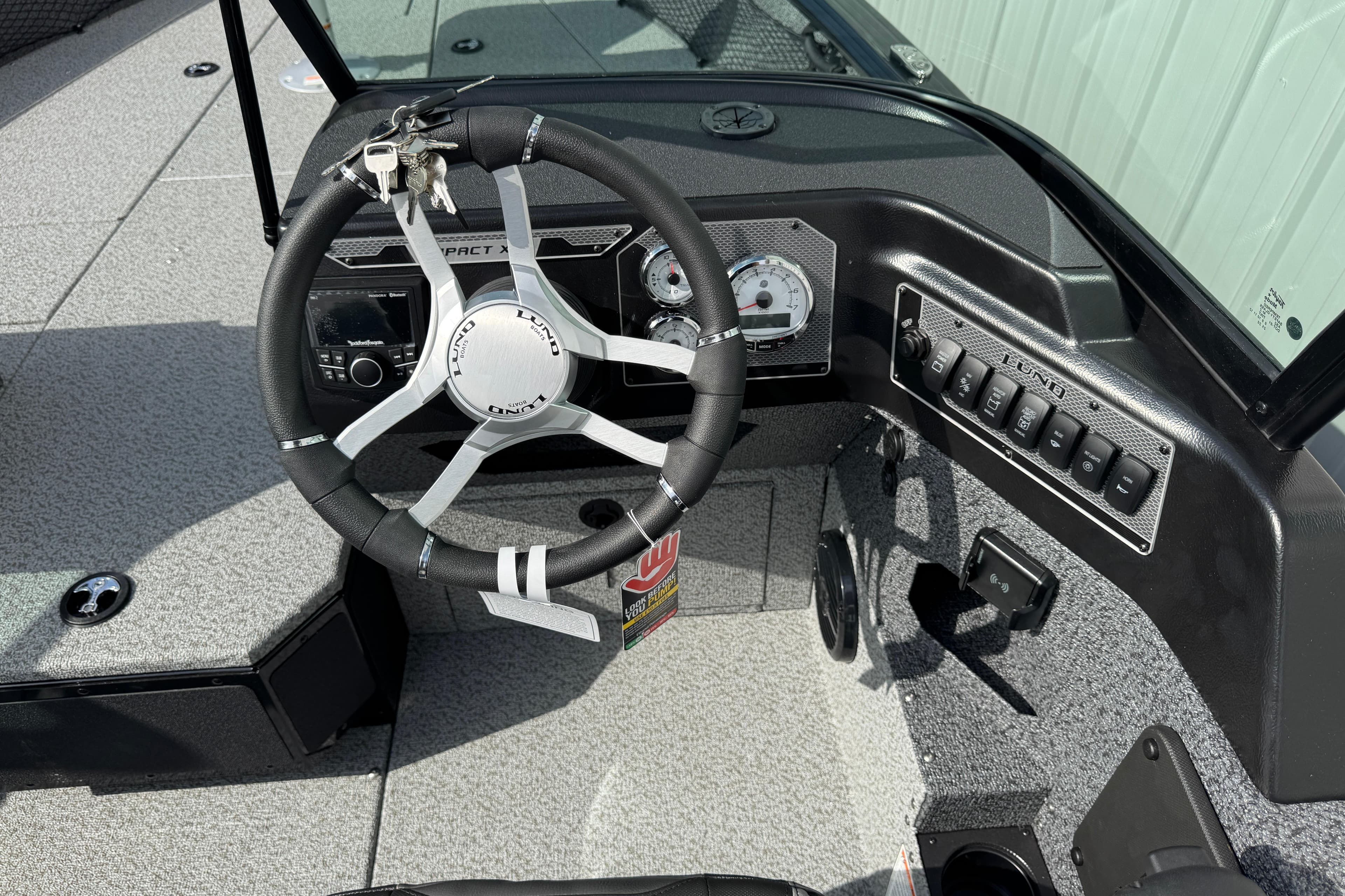 2026 Lund 2075 Impact XS boat dashboard with steering wheel and control panel.