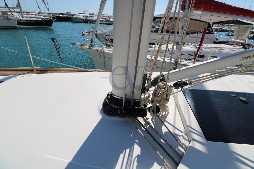 Deck view of 2016 Delphia Maxi 1200 sailboat in marina, showing mast and rigging.