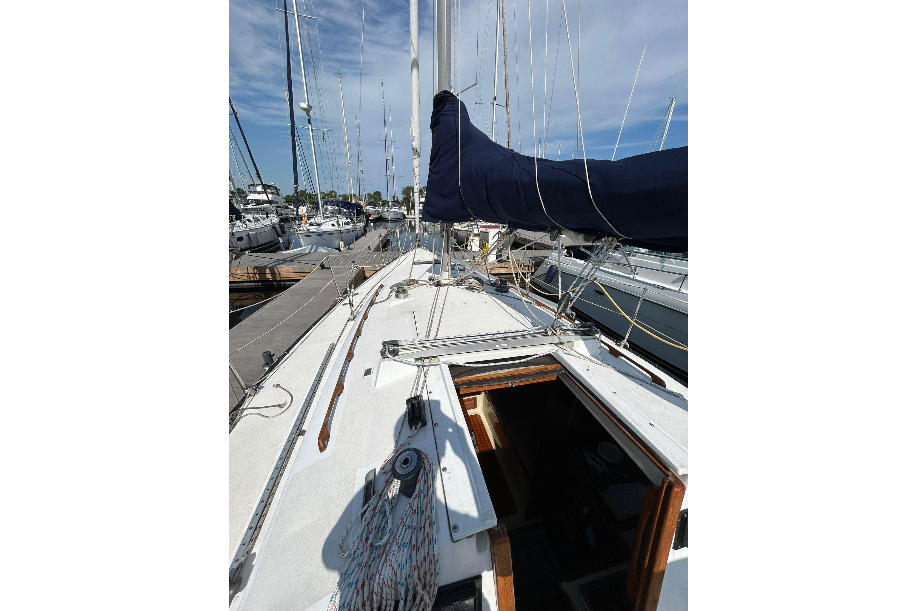 1984 C&C 34 sailboat docked at marina, view of deck and mast.