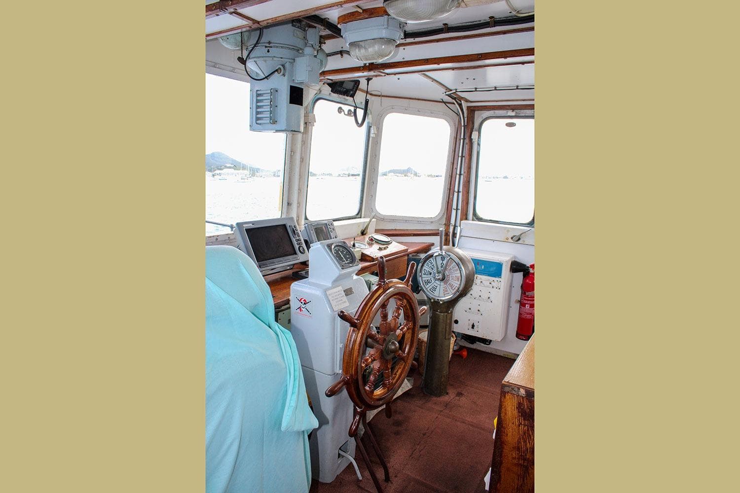 Interior of 1970 Custom CD Holmes Clovelly Class Tender Fleet, featuring steering wheel and navigation equipment.