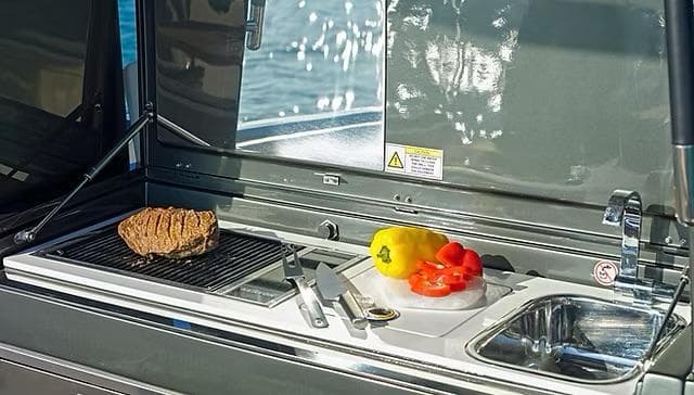 Outdoor kitchen on Schaefer V33 yacht with grill, vegetables, and sink, 2025 model.